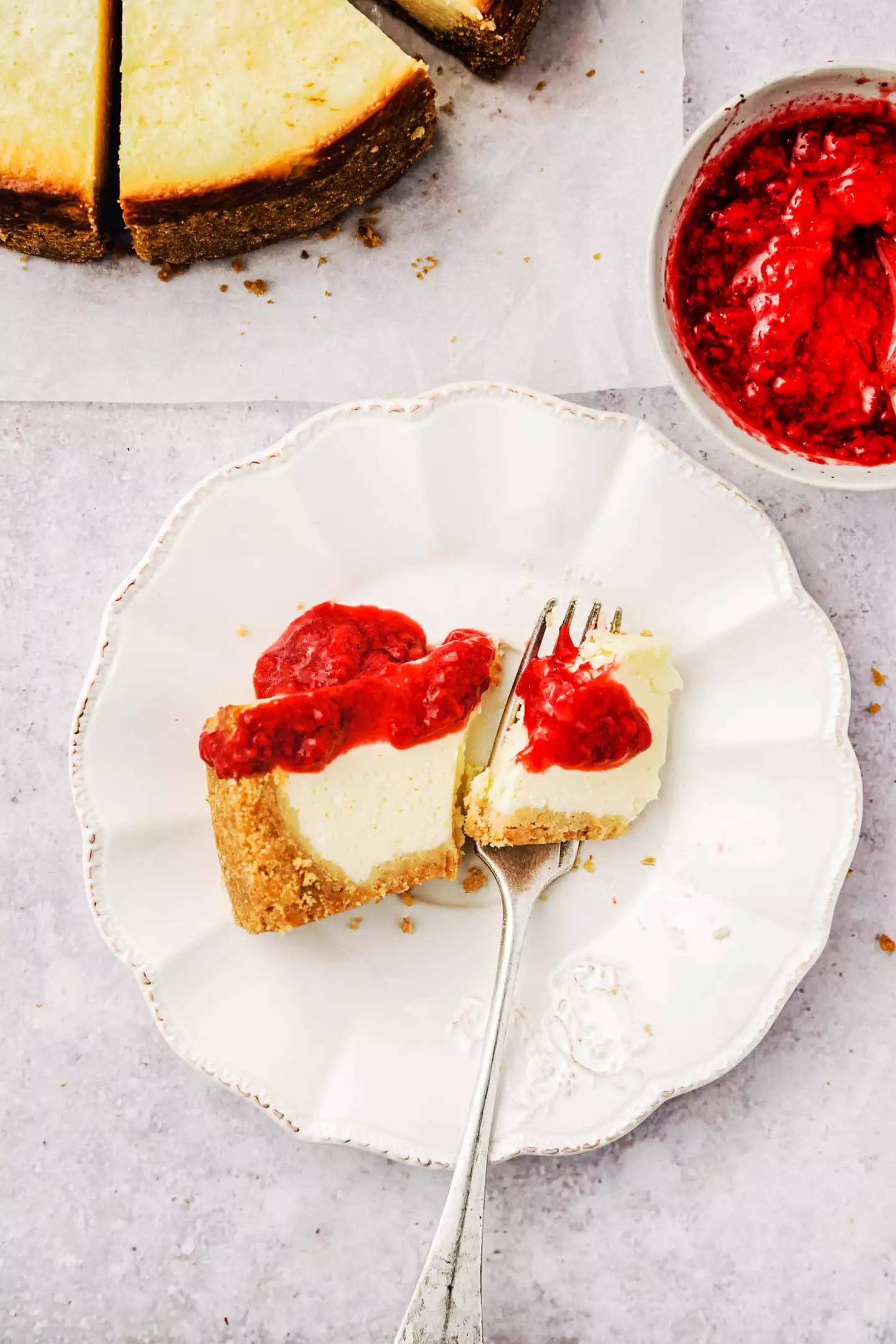 Part de cheesecake dans une assiette avec du coulis de fruits