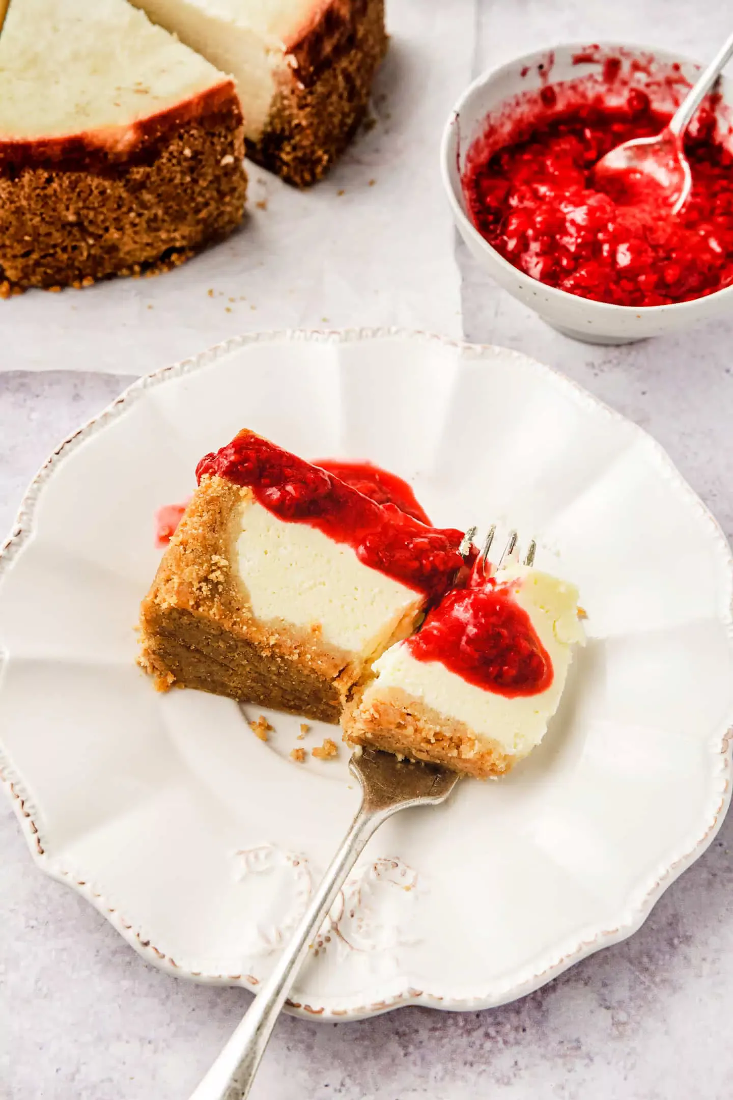 Assiette à dessert avec une part de cheesecake et du coulis de fruits