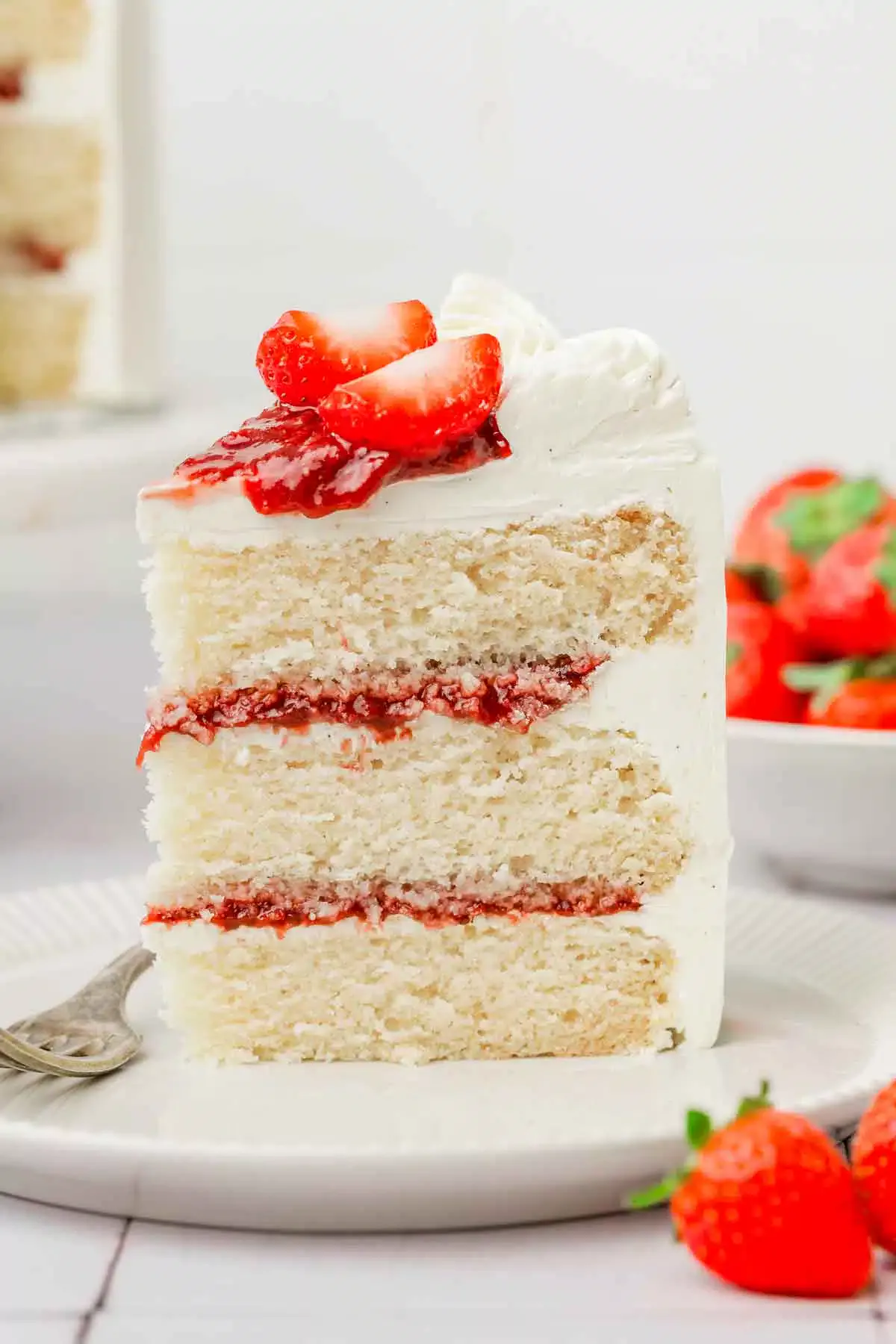 slice of strawberry vanilla cake with strawberry filling and fresh strawberry