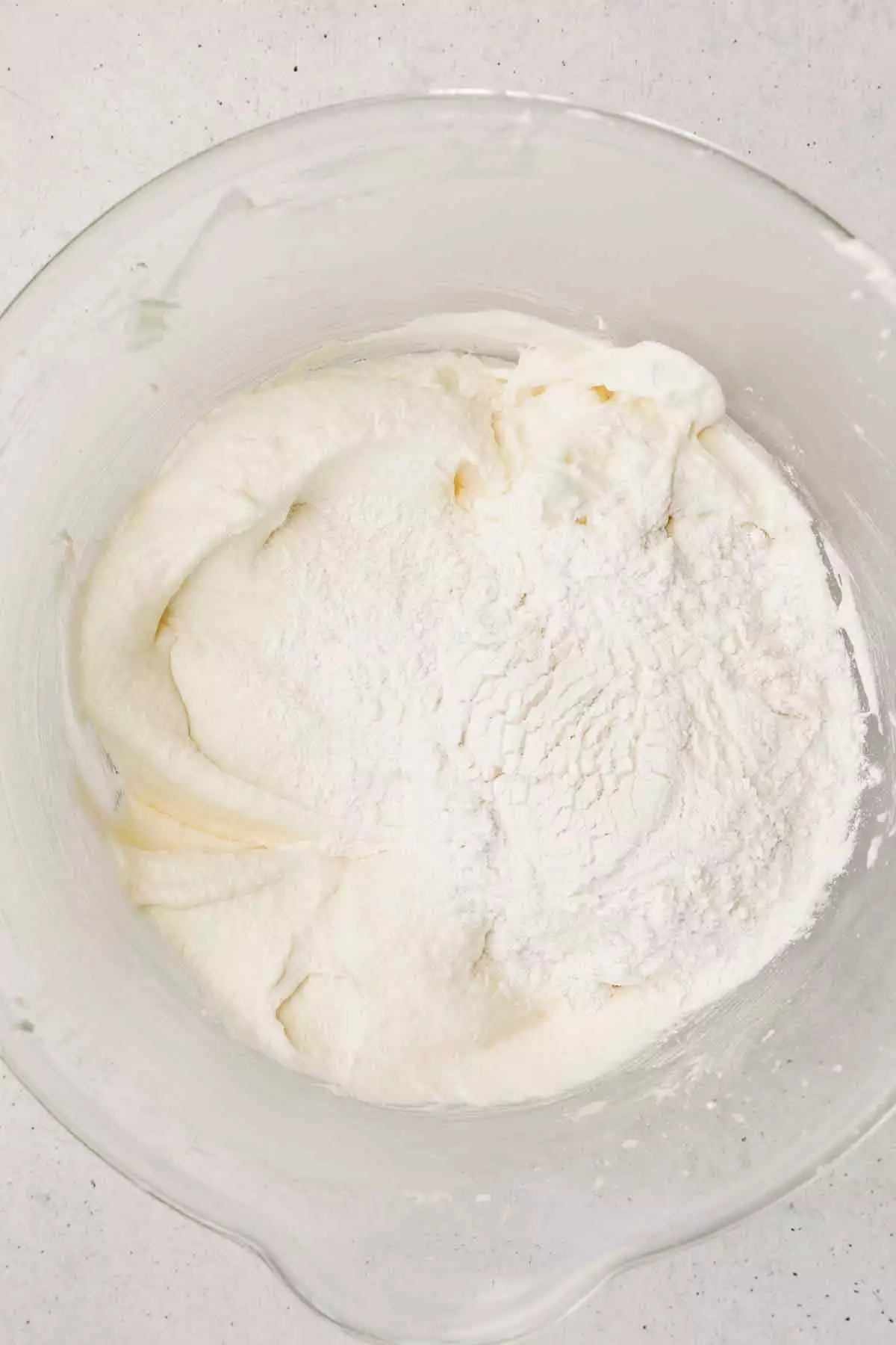 mixing white cake batter with flour mixture