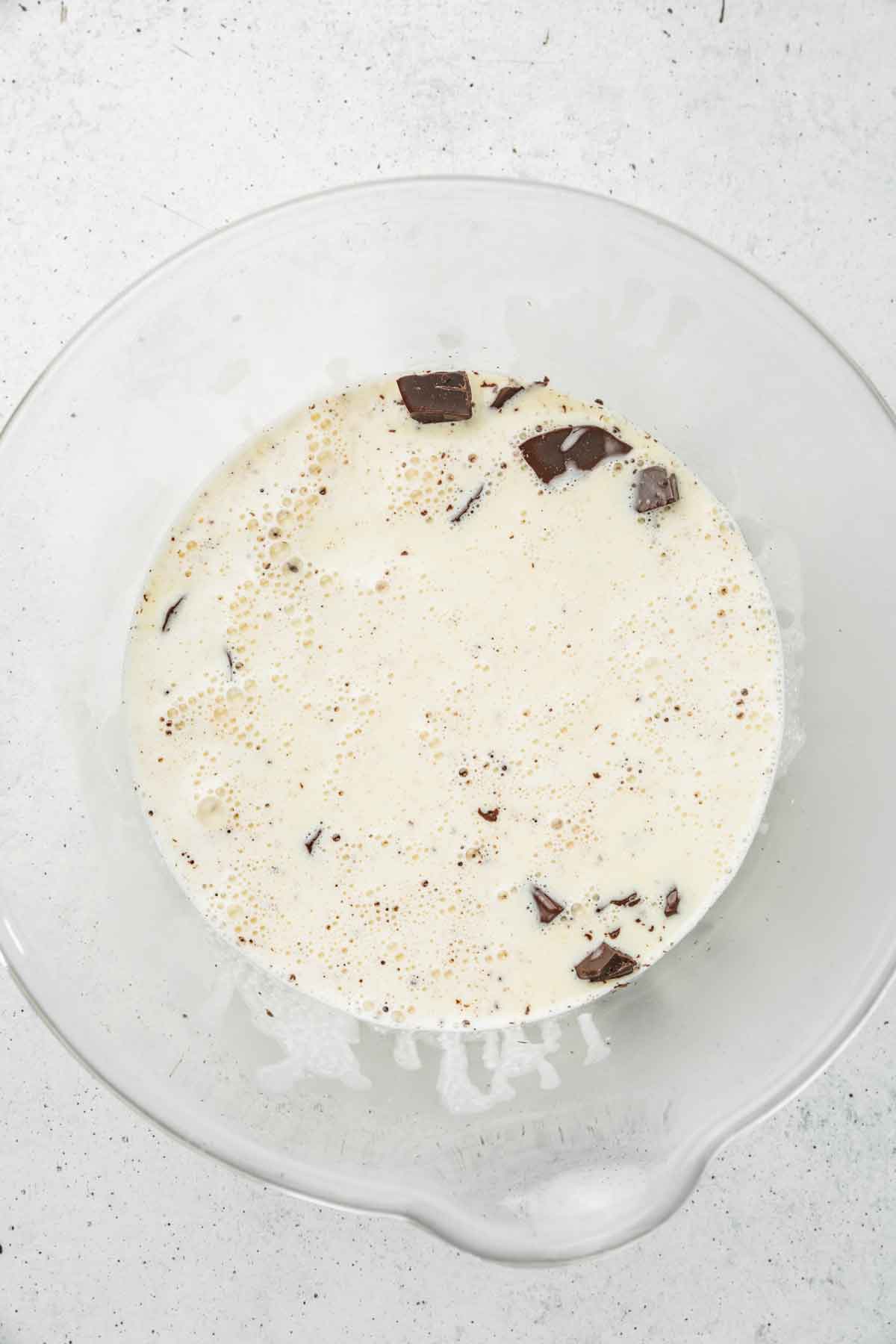 Heavy cream poured over chopped chocolate to make ganache frosting