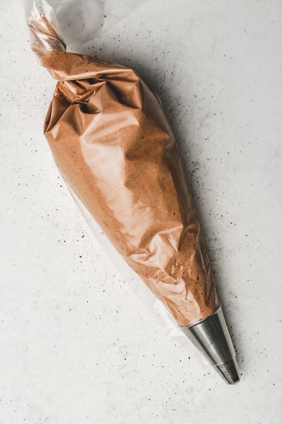 Large piping bag with chocolate macaron batter