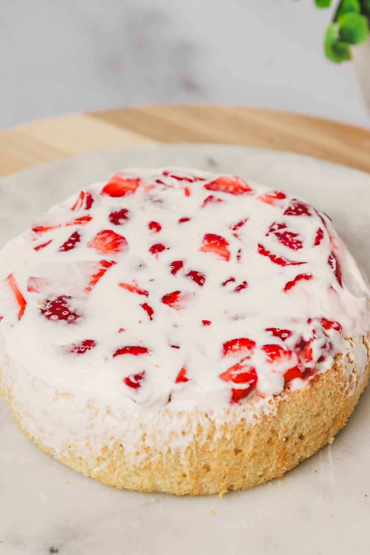 Strawberry cream cake assembly with cream and berries