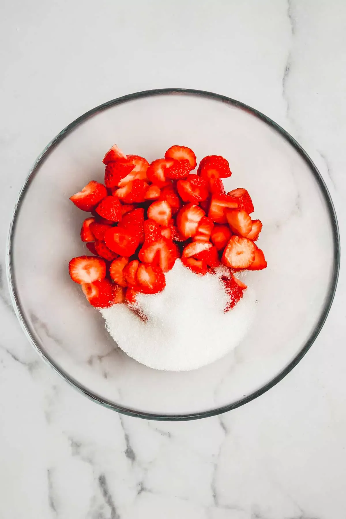 Medium bowl with strawberry pieces and powdered sugar