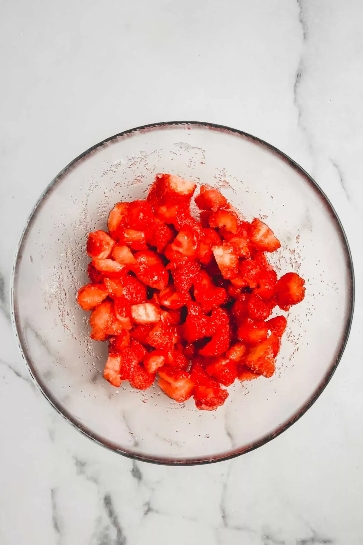 Medium bowl with chopped strawberries and sugar