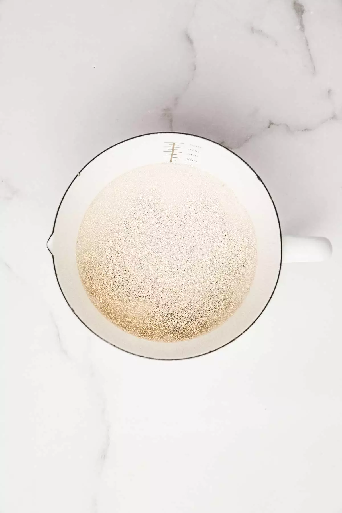 Bowl with yeast, warm milk, cocoa, flour, butter, and sugar for chocolate dough