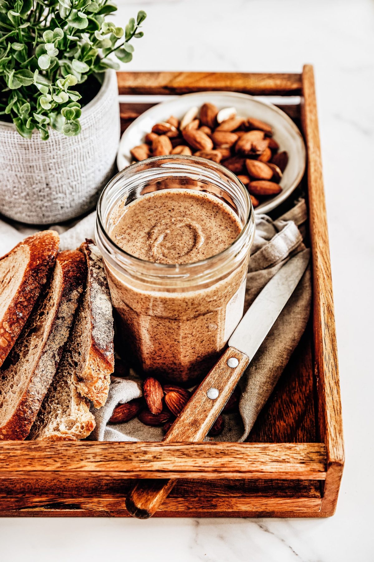 almond butter on a jar on a board tray
