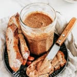 Plateau avec bocal de pâte aux amandes un couteau et une tartine de pain