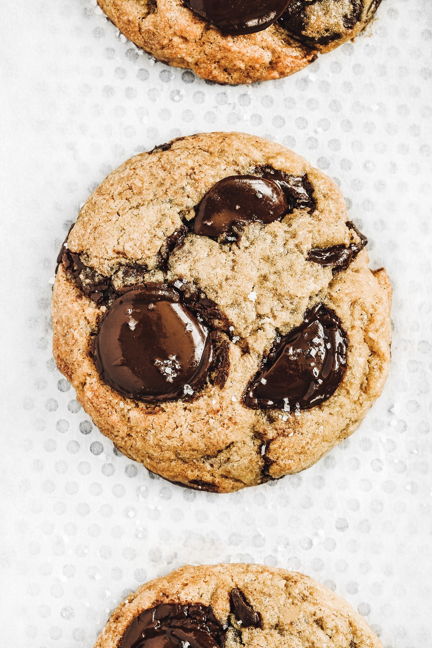 One chocolate chip cookie on a baking sheet