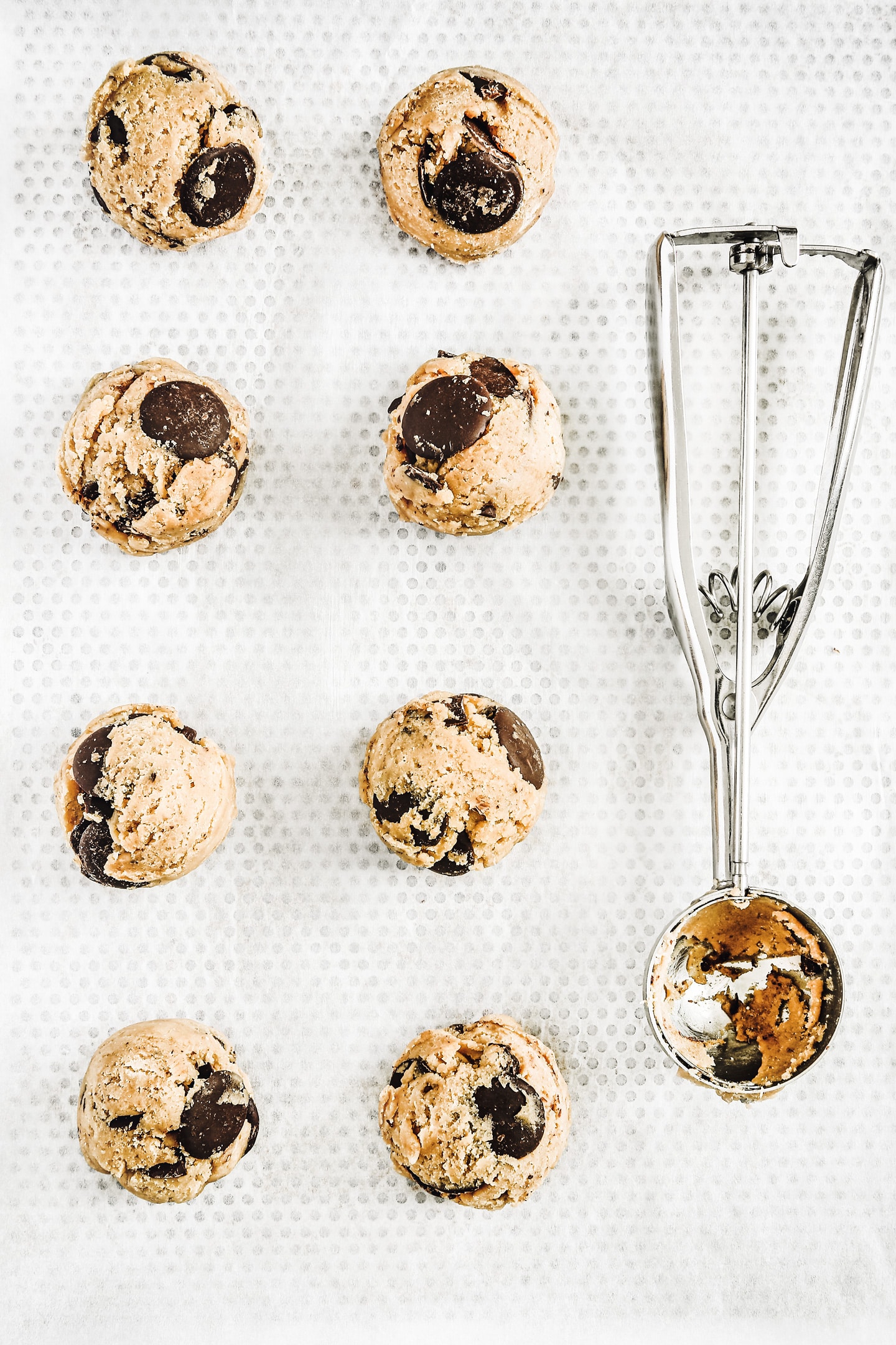 cookie dough balls on baking sheet before baking chocolate chip cookies