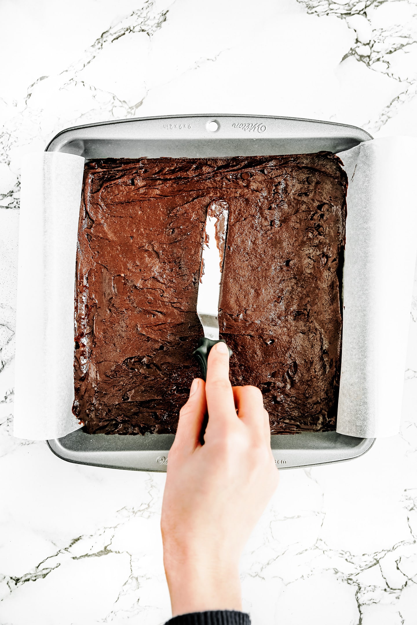 Chocolate chip brownies  in a square pan before baking