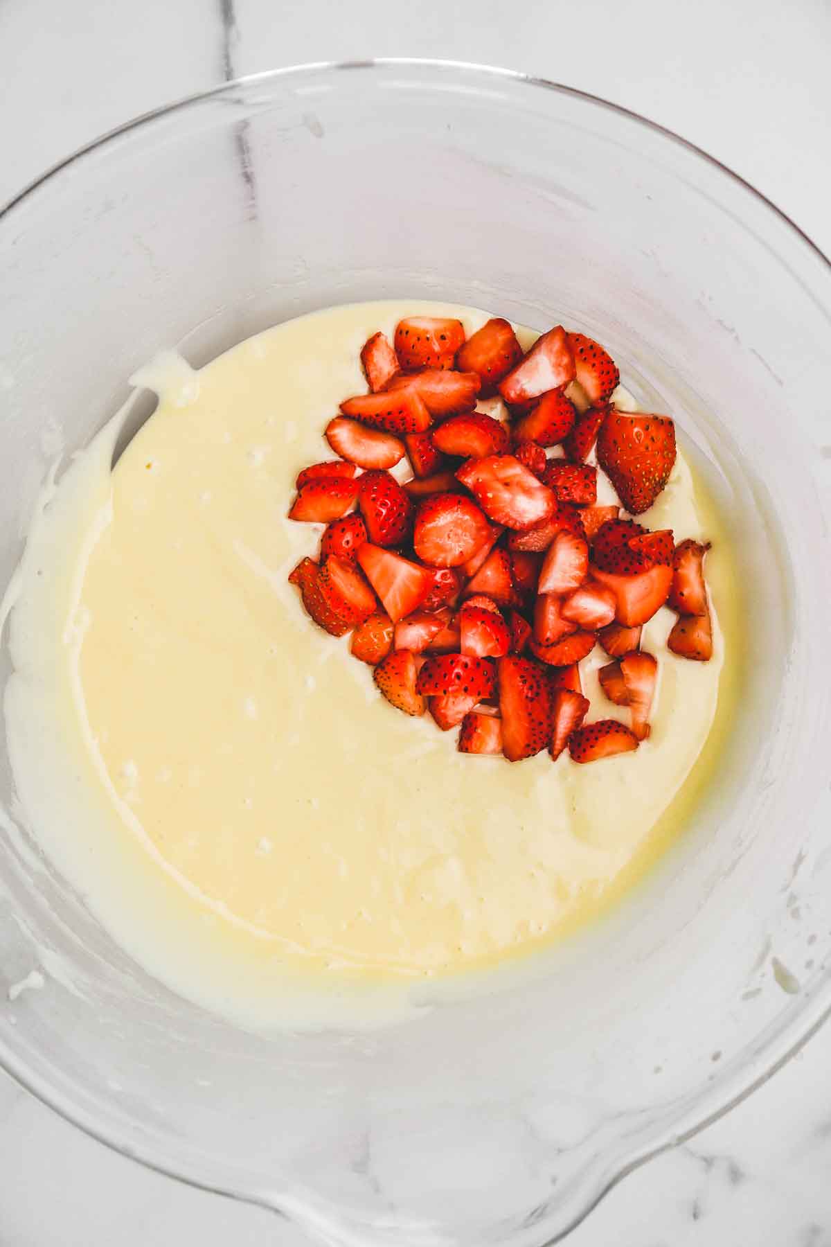 mixing bowl with cake batter and fresh strawberry