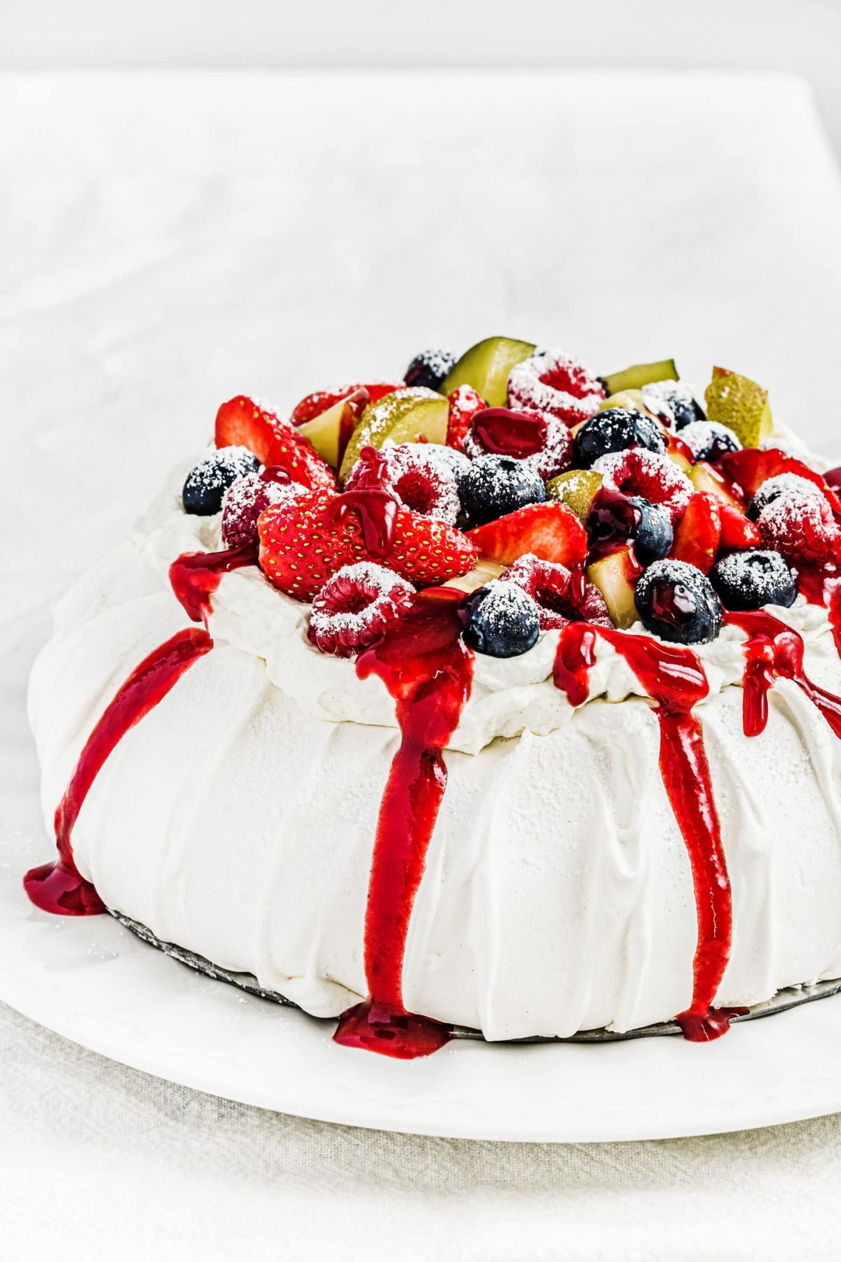 Red fruits pavlova with fruit coulis
