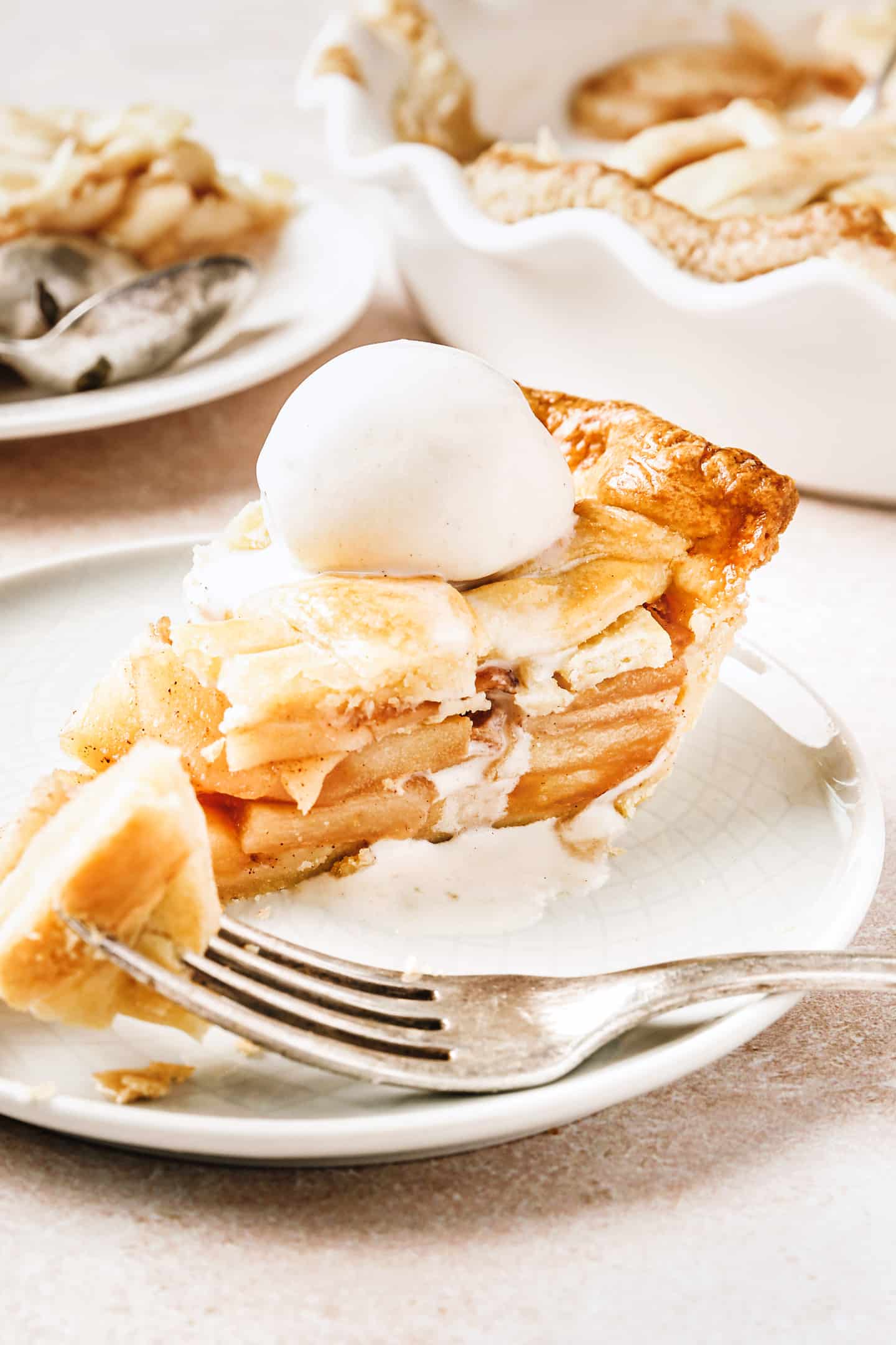 Part de tourte aux pommes dans une assiette avec de la glace à la vanille