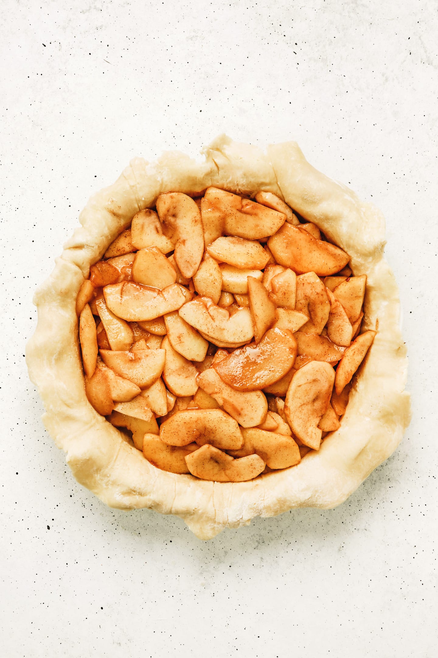 Moule à tarte avec de la pâte et des pommes