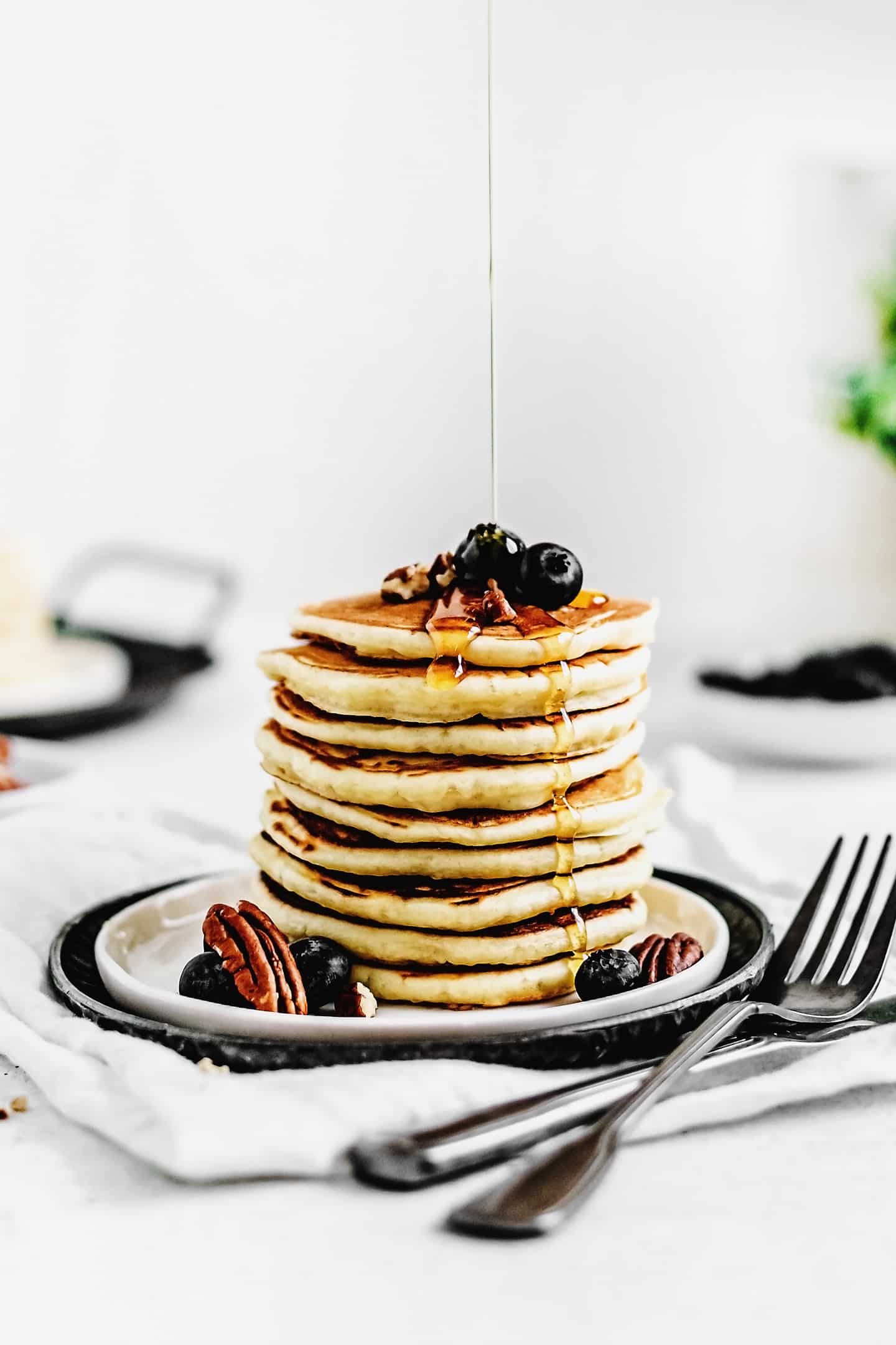 A breakfast table set with a stack of pancakes, orange juice, and coffee, ready to enjoy.