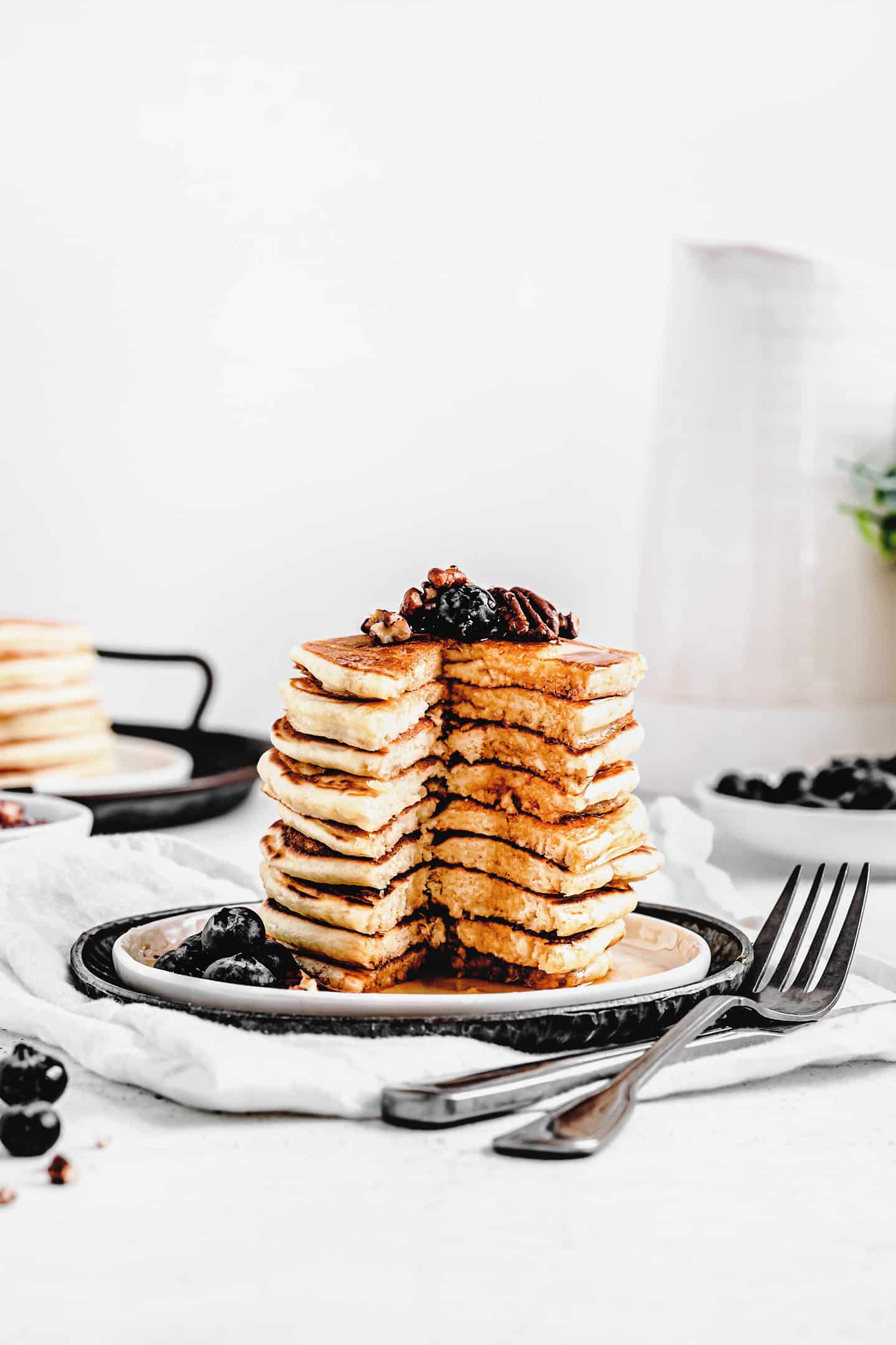 A breakfast table set with a stack of pancakes, orange juice, and coffee, ready to enjoy.
