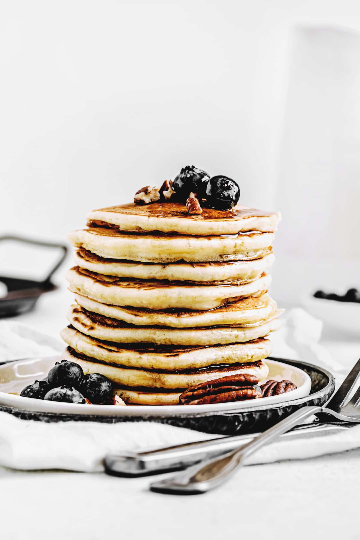 A breakfast table set with a stack of pancakes, orange juice, and coffee, ready to enjoy.