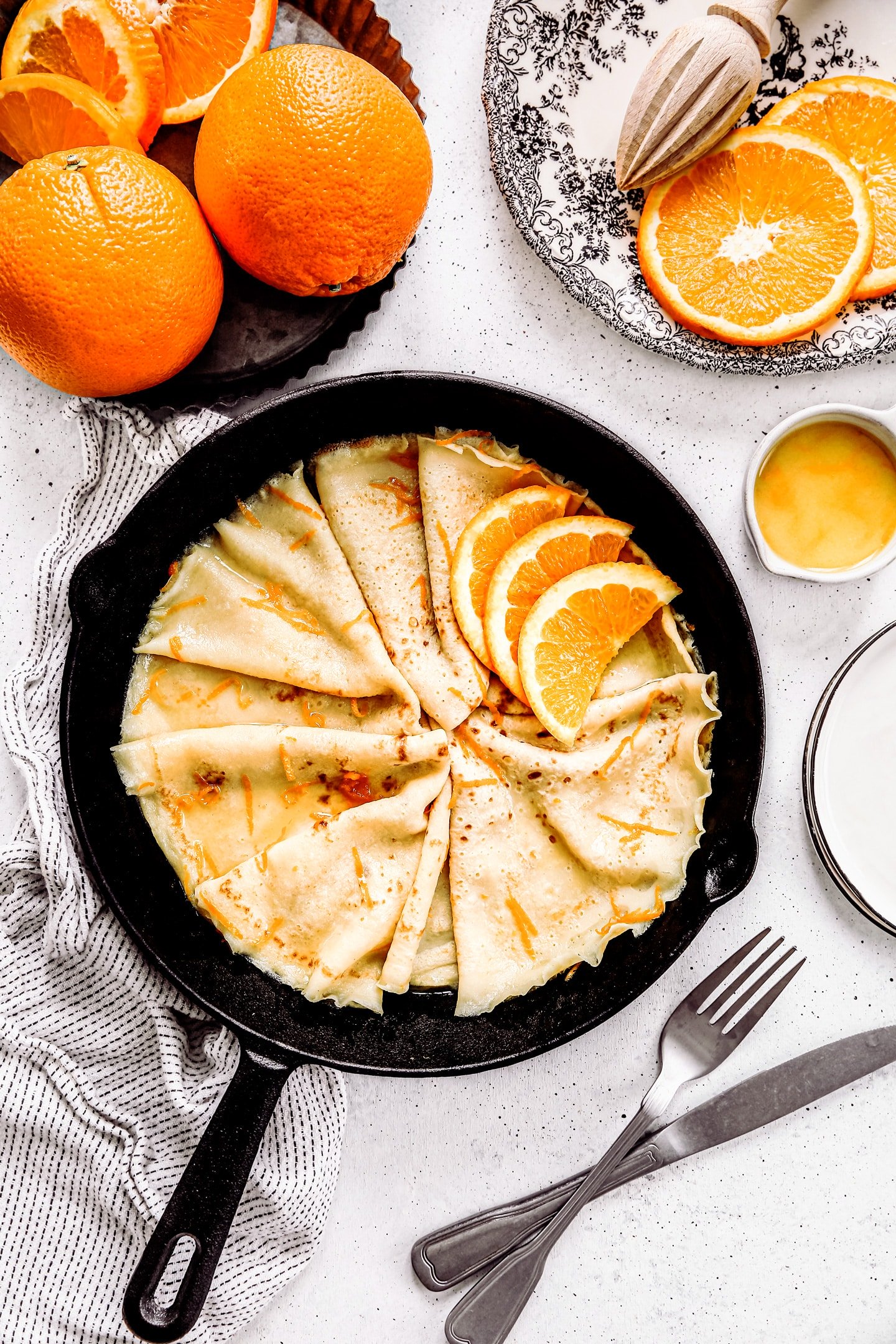 crepes suzette cooking in a skillet with orange slices