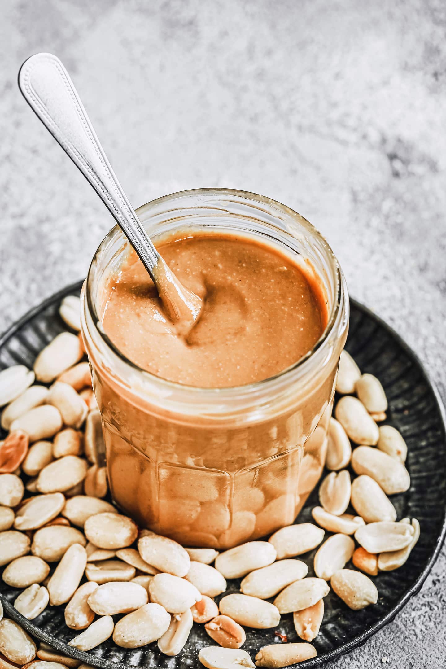 bocal avec de la purée de cacahuètes et une cuillère