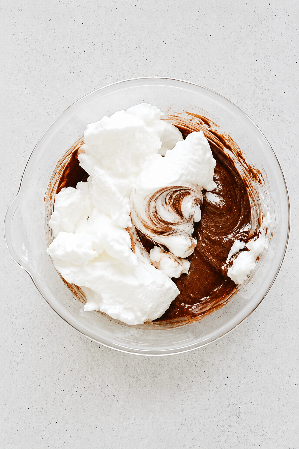 whipped egg whites folded into chocolate cake batter