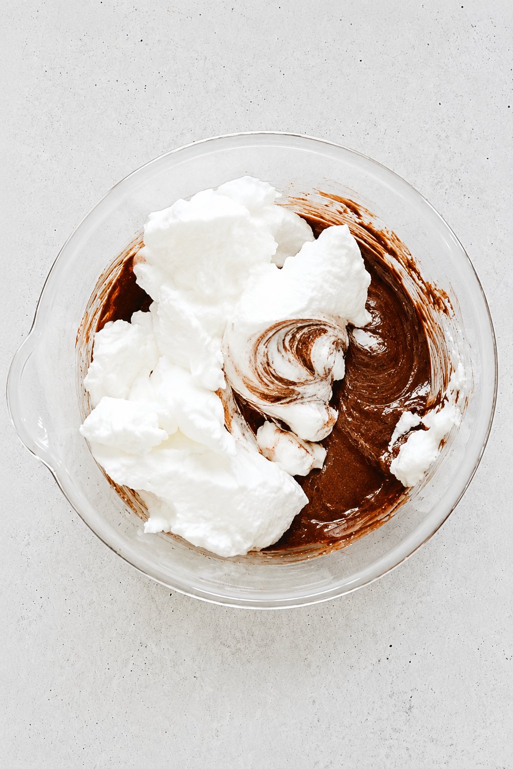 whipped egg whites folded into chocolate cake batter