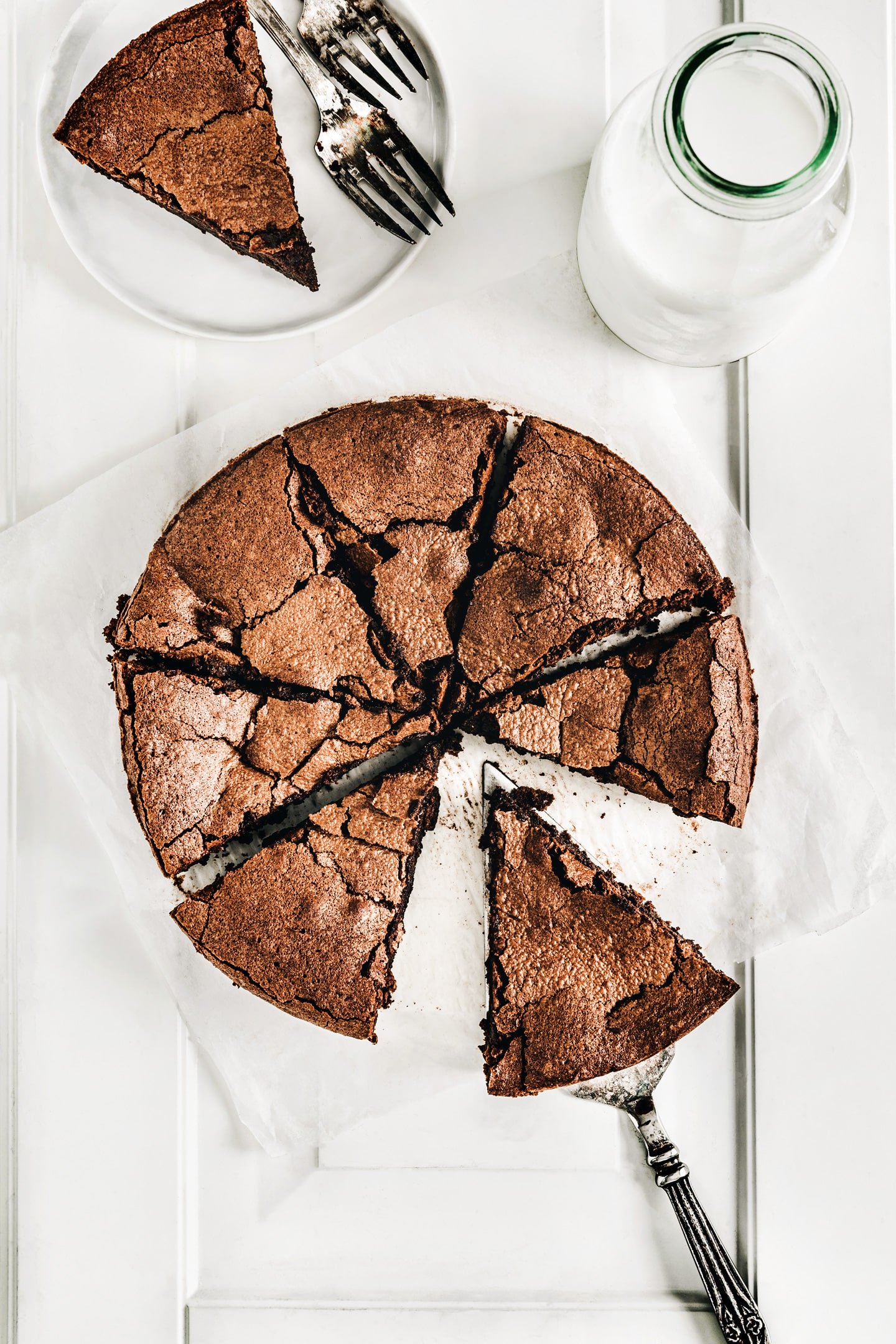 Flourless french chocolate cake on a table with a milk bottle 