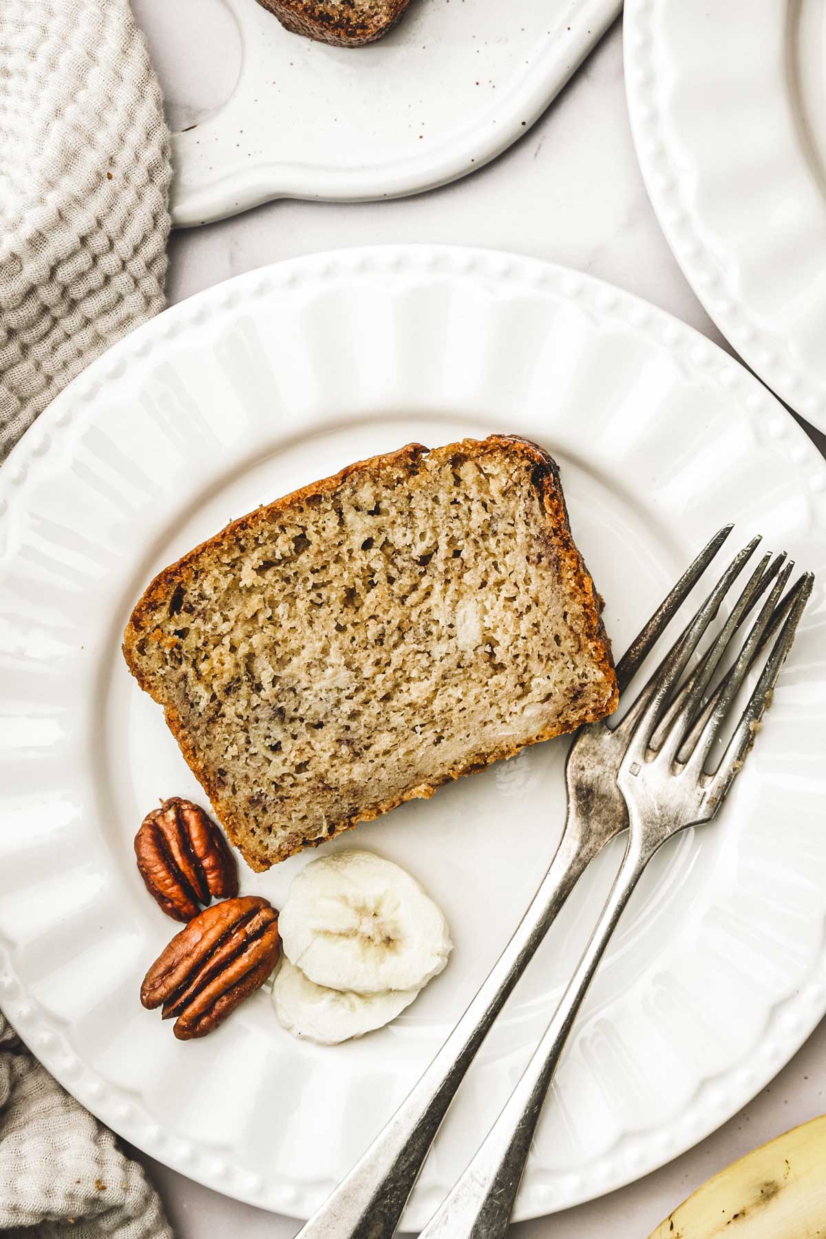 Buttermilk banana bread with forks and pecan nuts