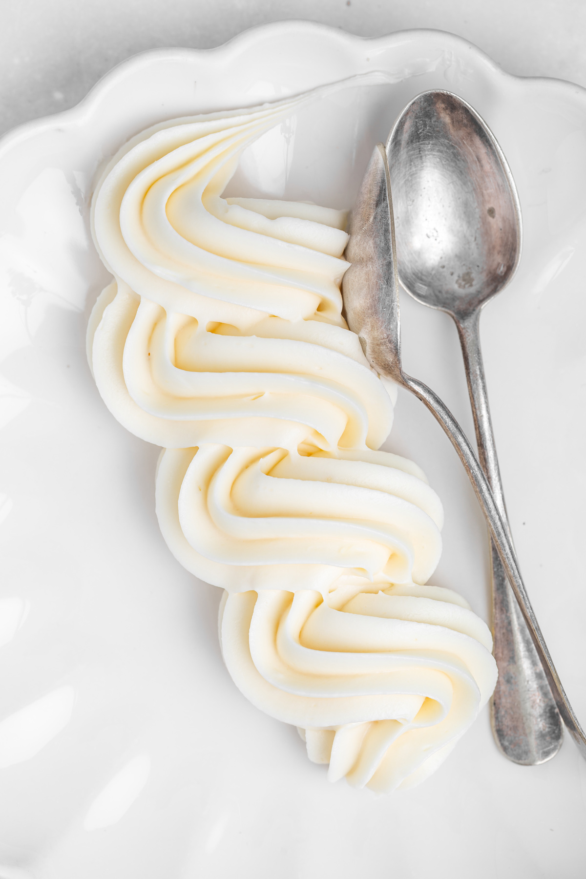 Cream cheese frosting piped with a piping bag on a plate