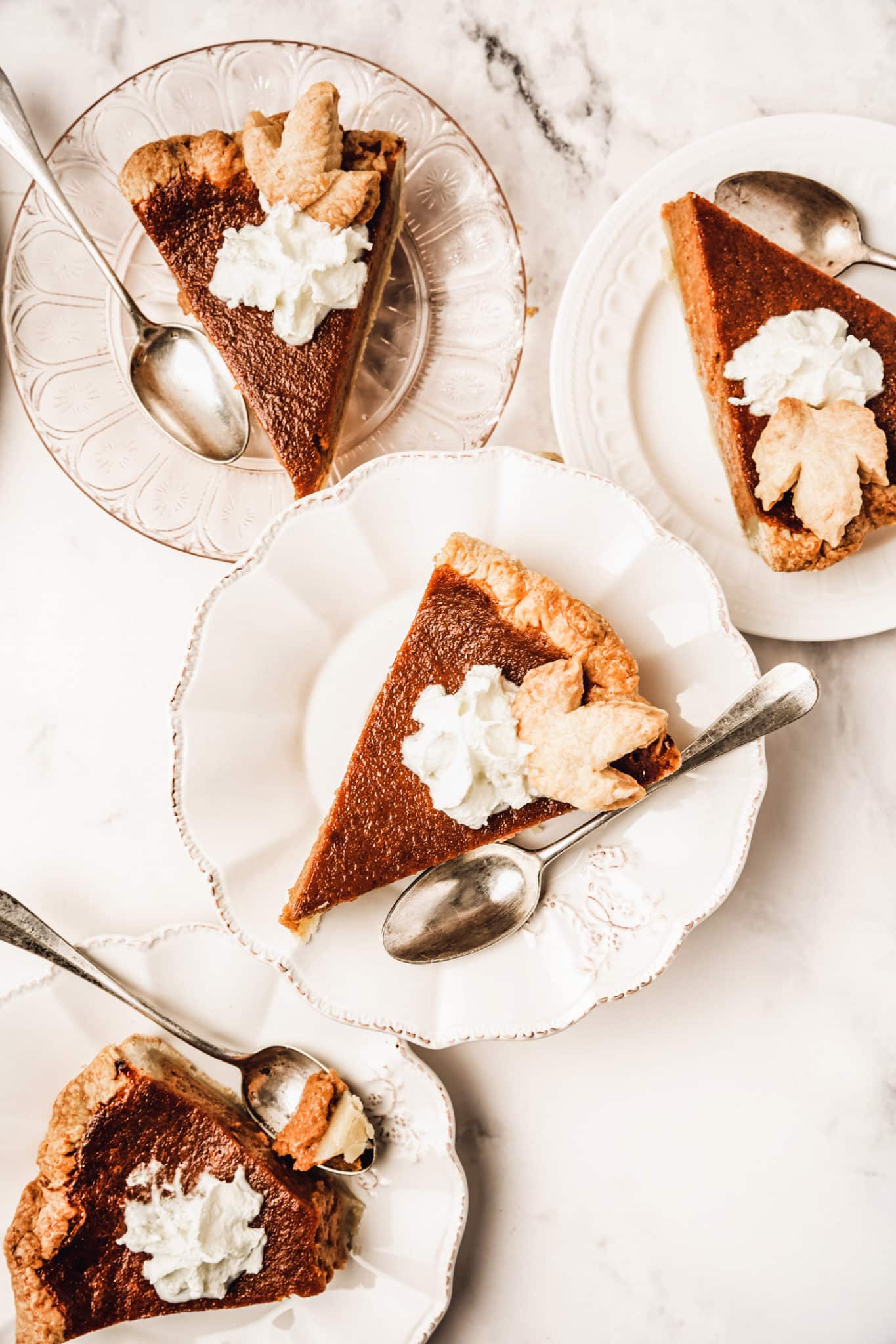 Plates with sliced pumpkin pie and teaspoon