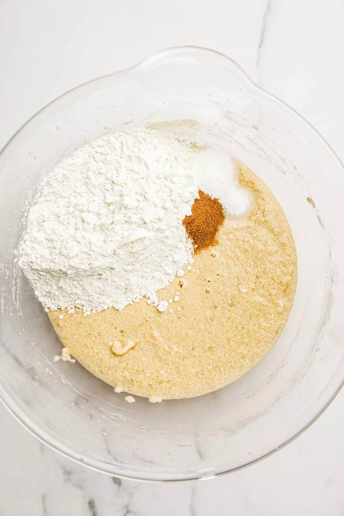 mixing bowl with banana bread batter and flour
