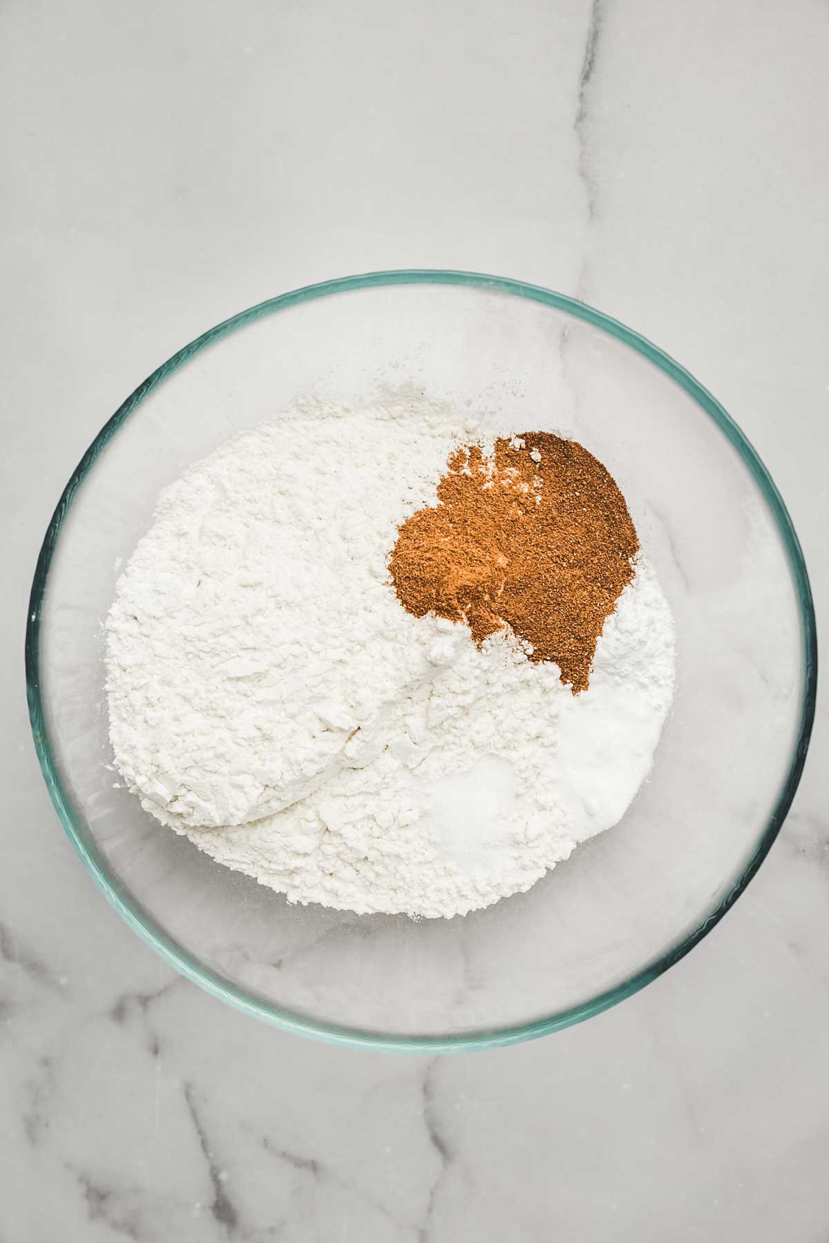 Dry ingredients for carrot cake cupcakes in a mixing bowl