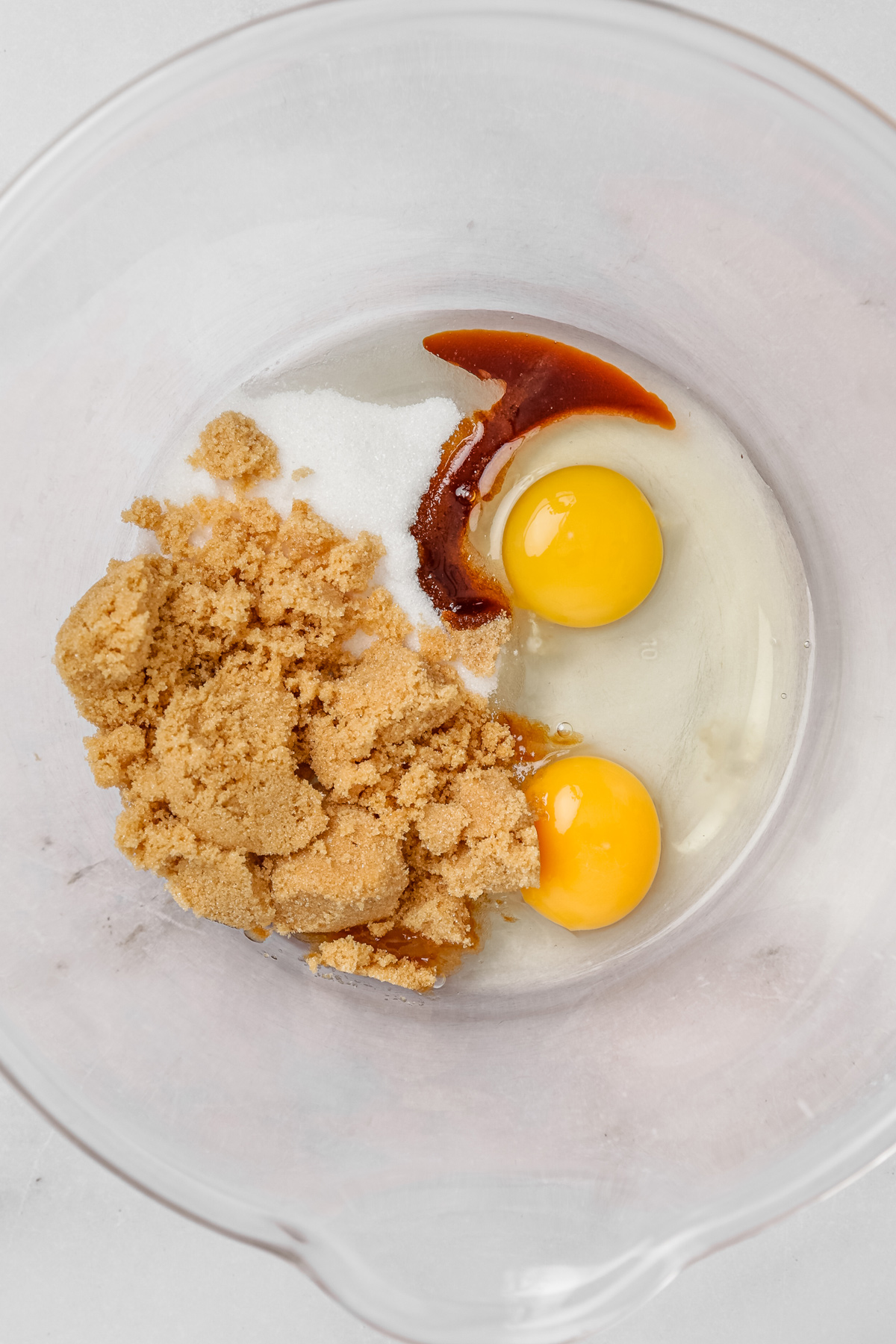 Wet ingredients for carrot cake cupcakes with sugar, eggs, and vanilla