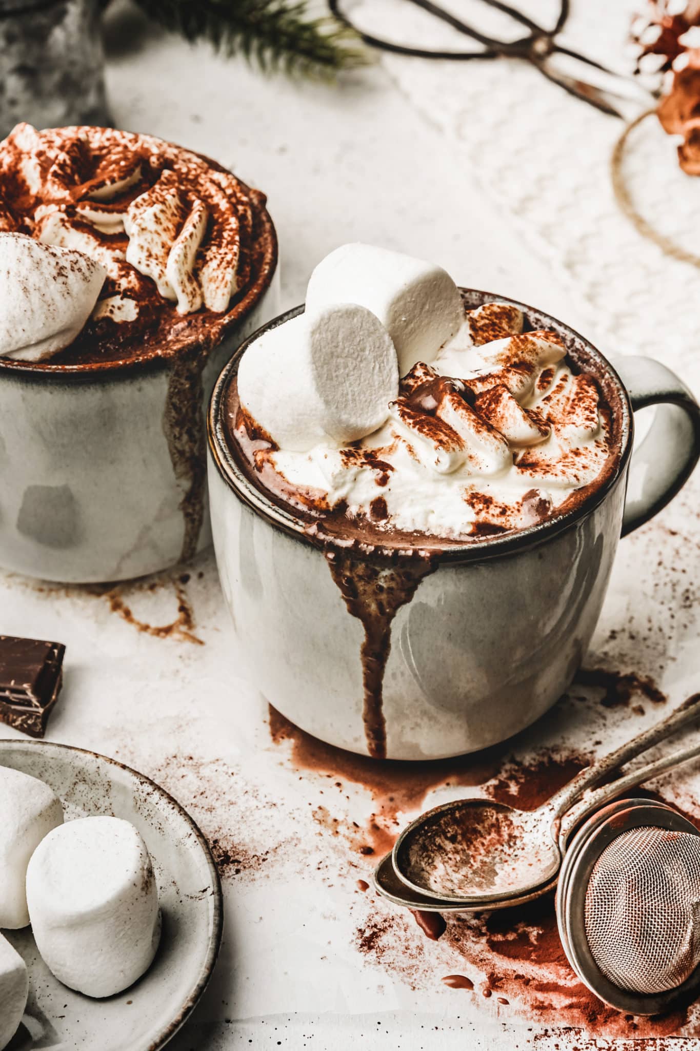 Deux tasses avec du chocolat chaud avec chantilly et guimauves