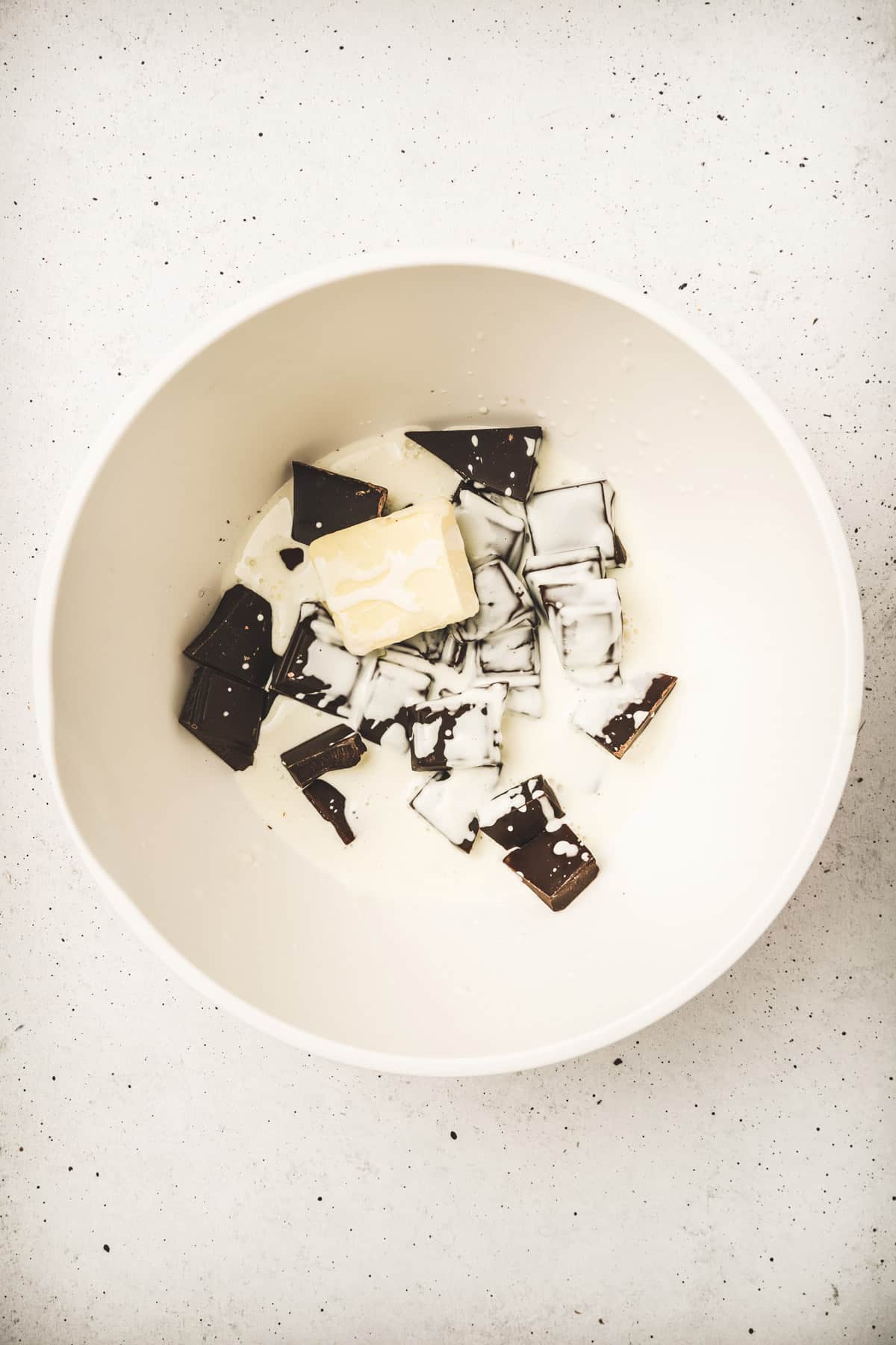 Bowl with chopped chocolate, hot cream and butter