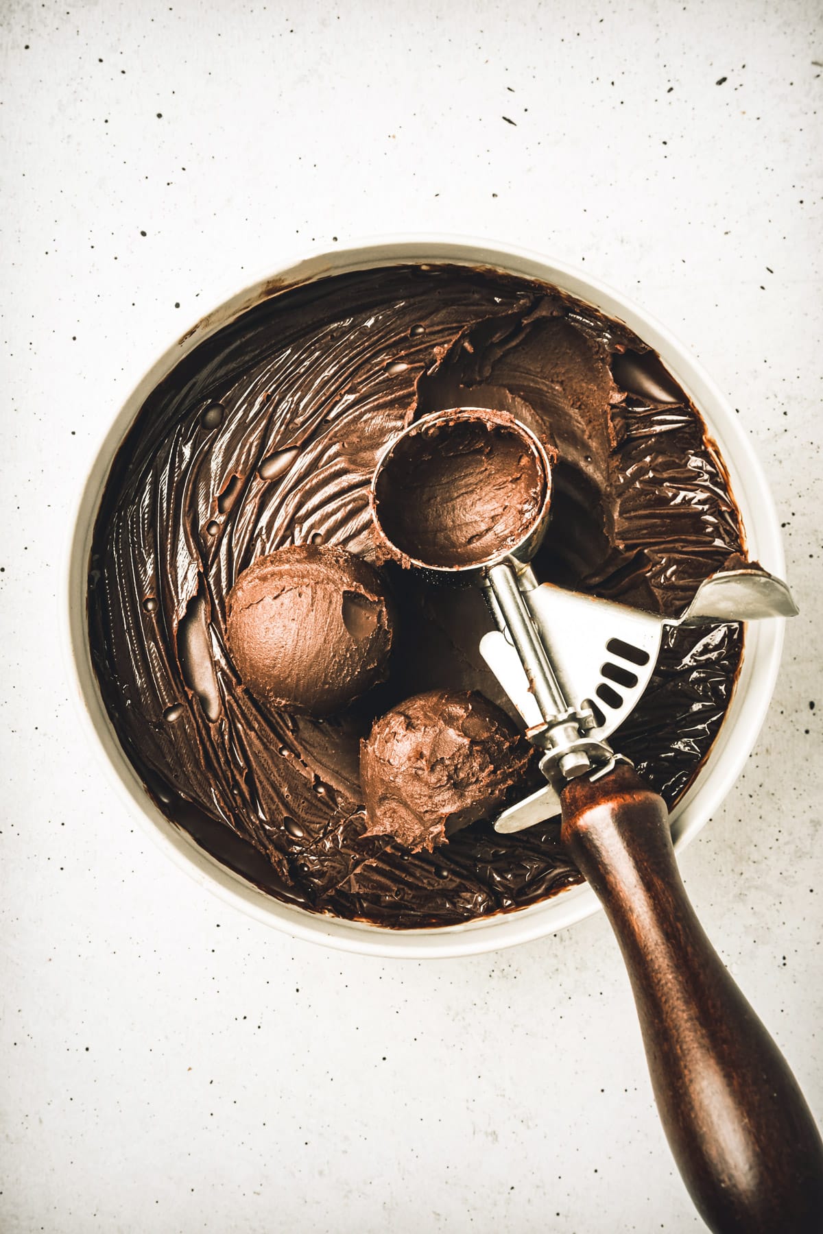 Bowl with dark chocolate ganache with a ice cream scoop