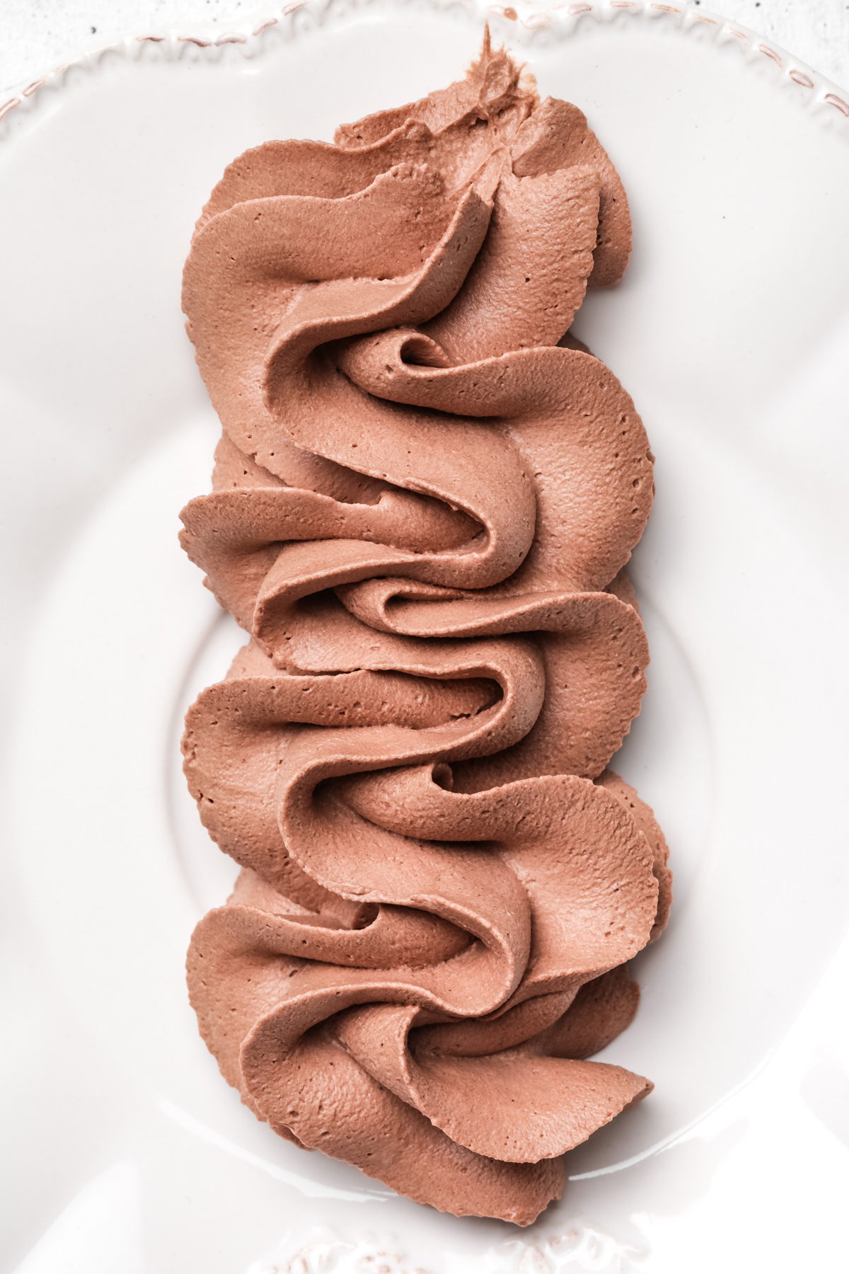 piped chocolate mascarpone frosting on a plate
