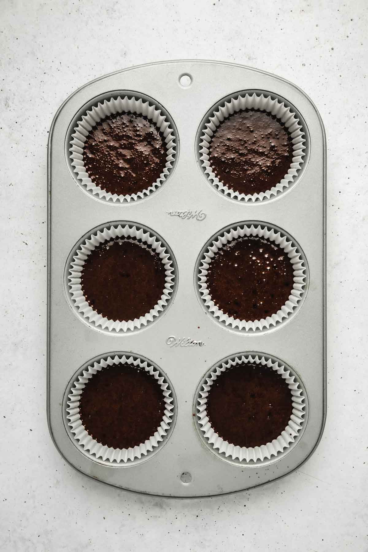 muffin pan with chocolate cupcakes batter