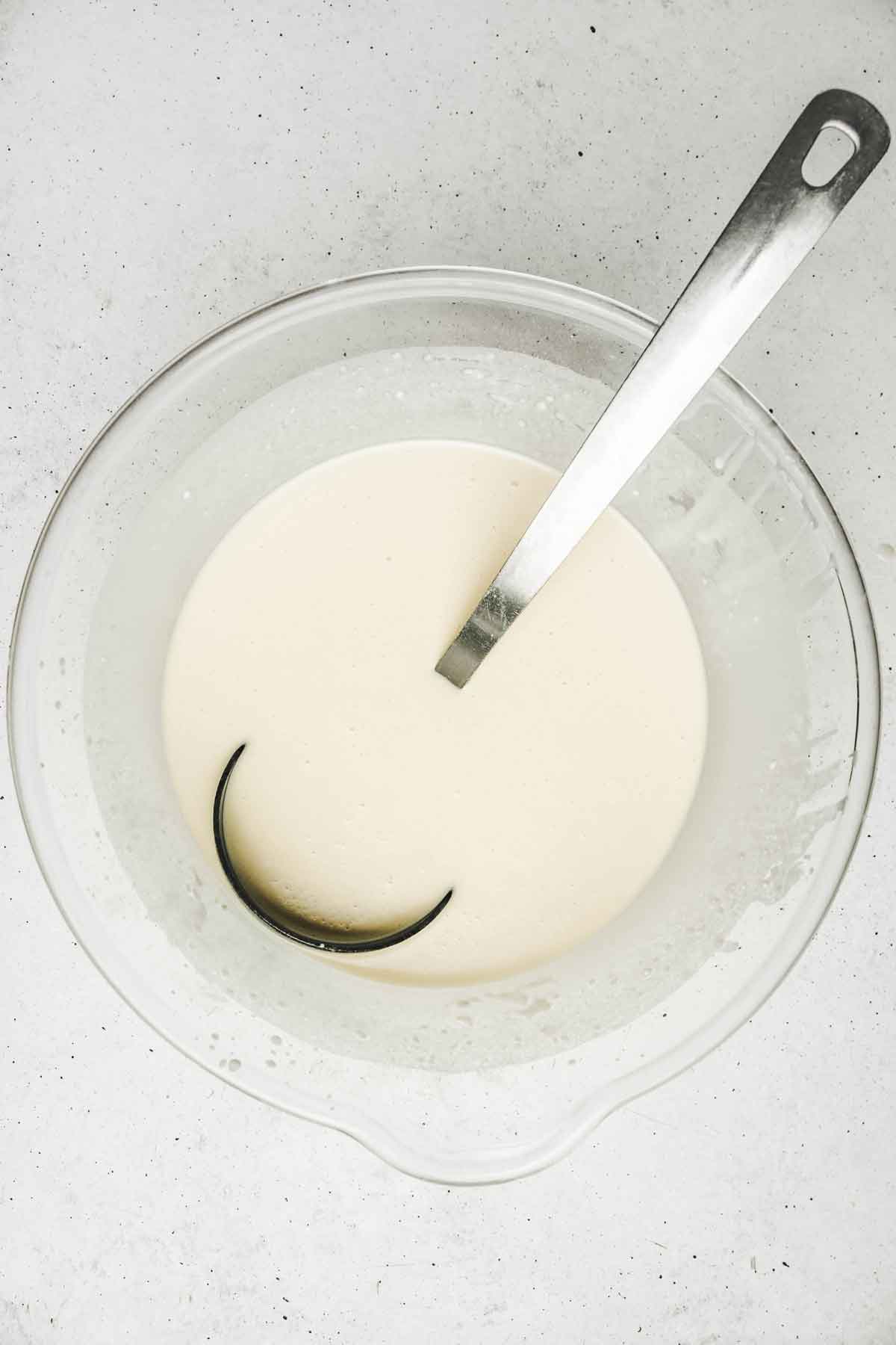Grand saladier avec de la pâte à crêpe et une louche