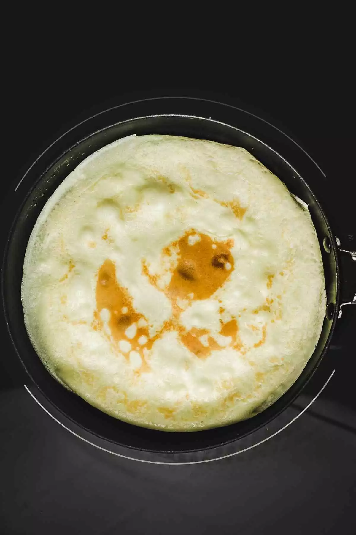 Crepe cooking in a non-stick pan