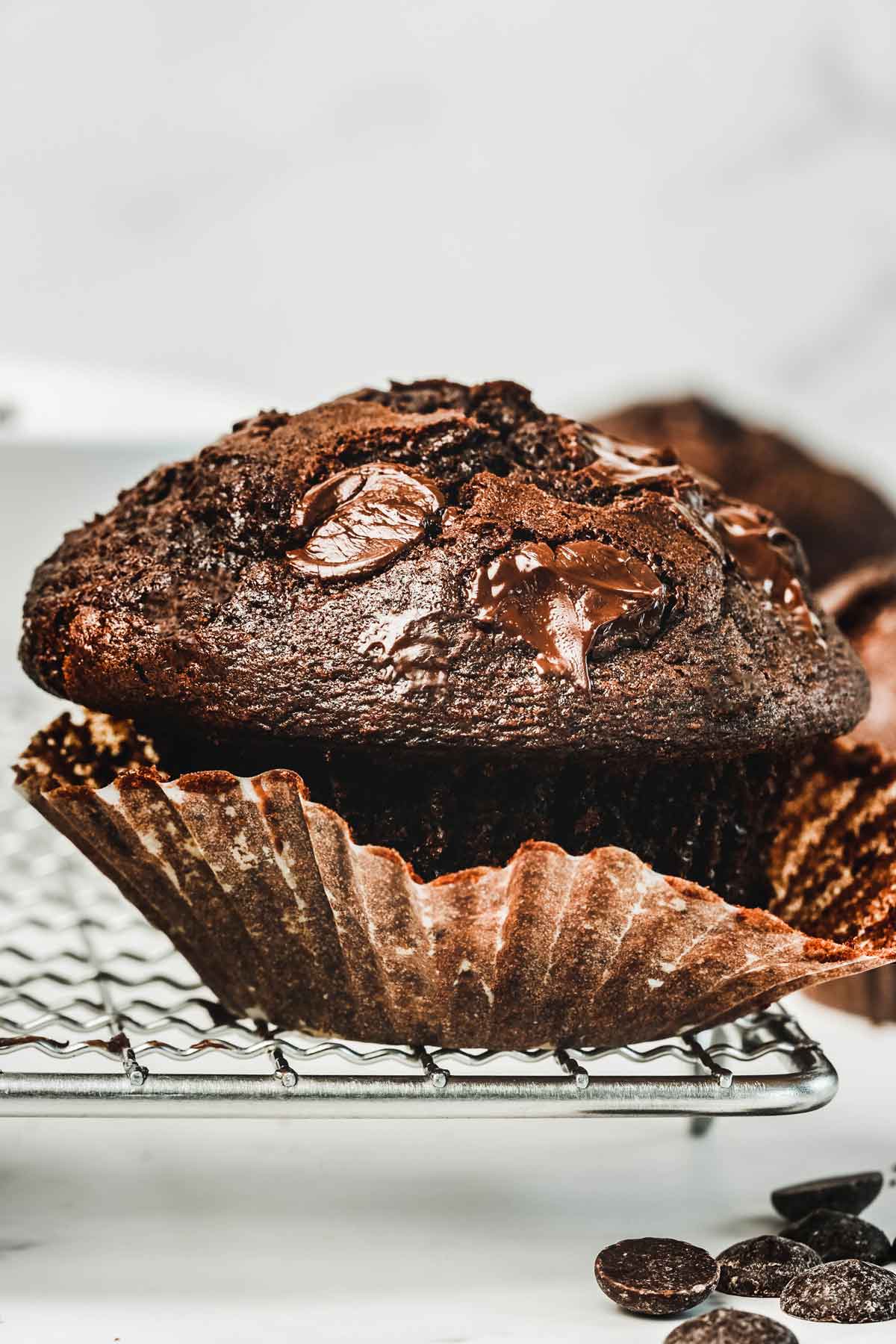 A large chocolate muffin on a cooling rack