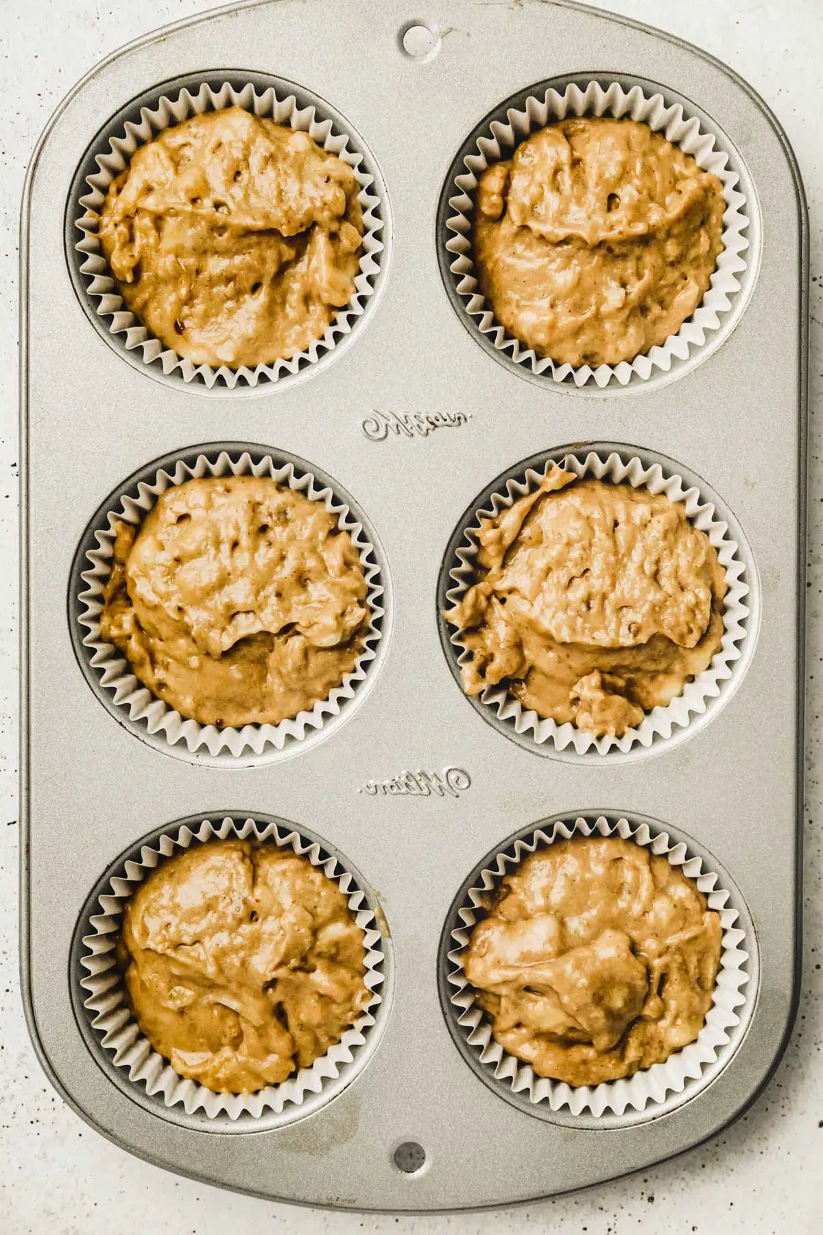 muffin pan with muffins before baking