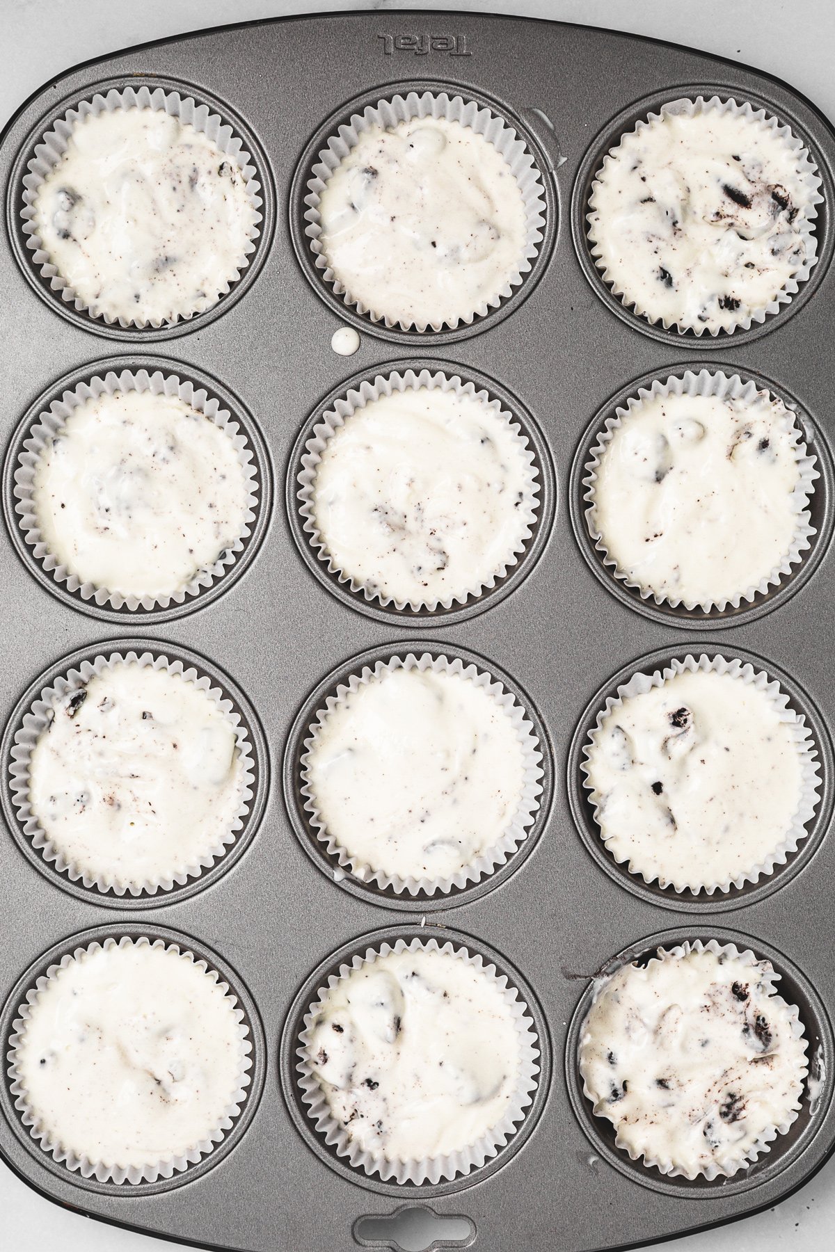 muffin pan filled with mini oreo cheesecakes before baking