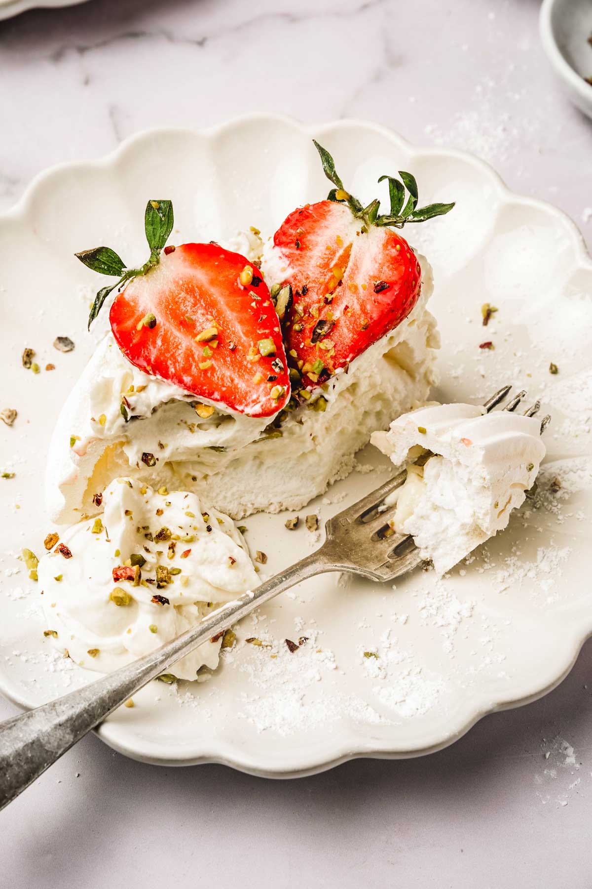 sliced pavlova with strawberry and a fork