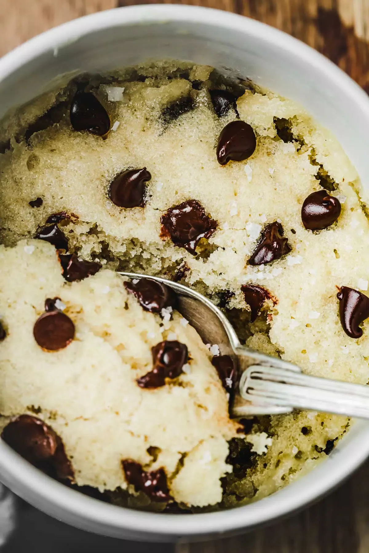 Chocolate chip cake in a mug with a spoon