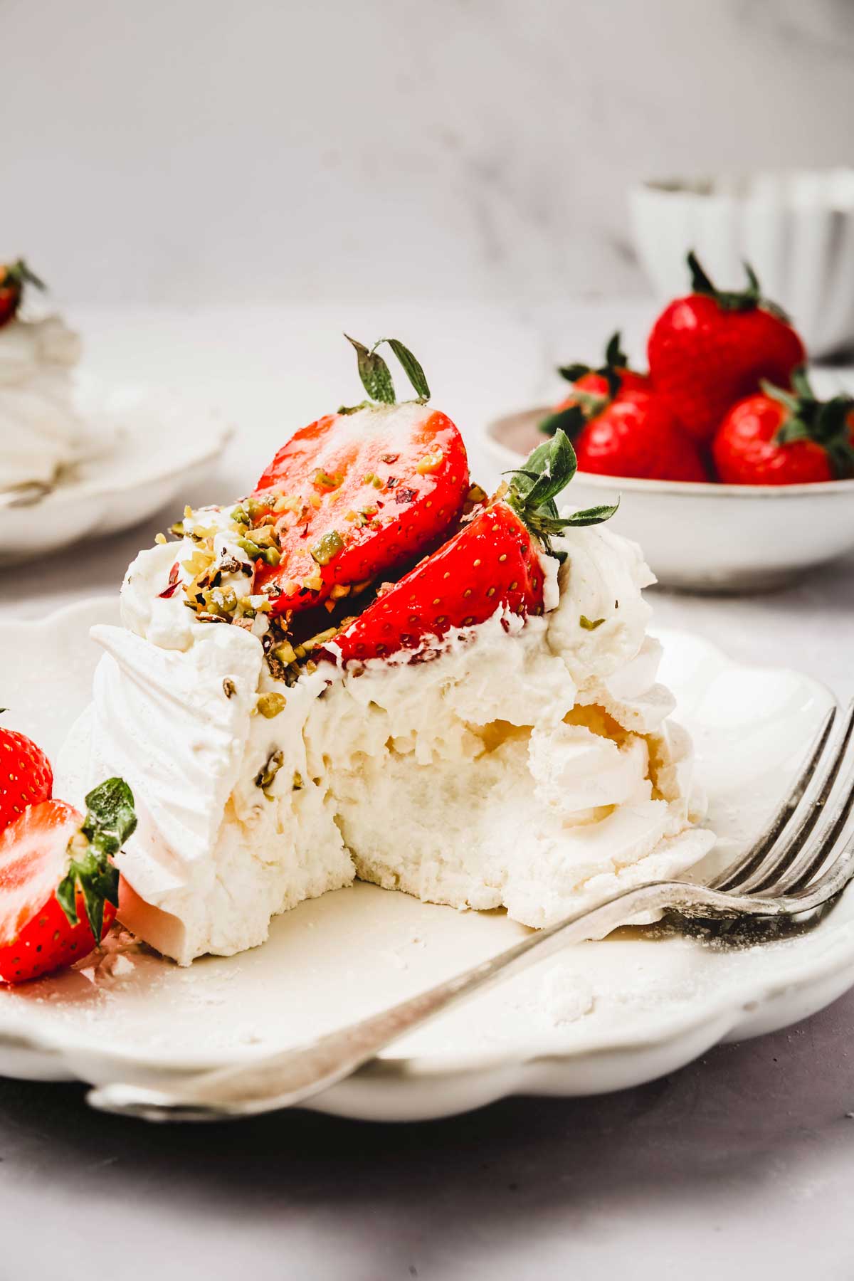 Pavlova aux fraises dans une assiette avec une fourchette