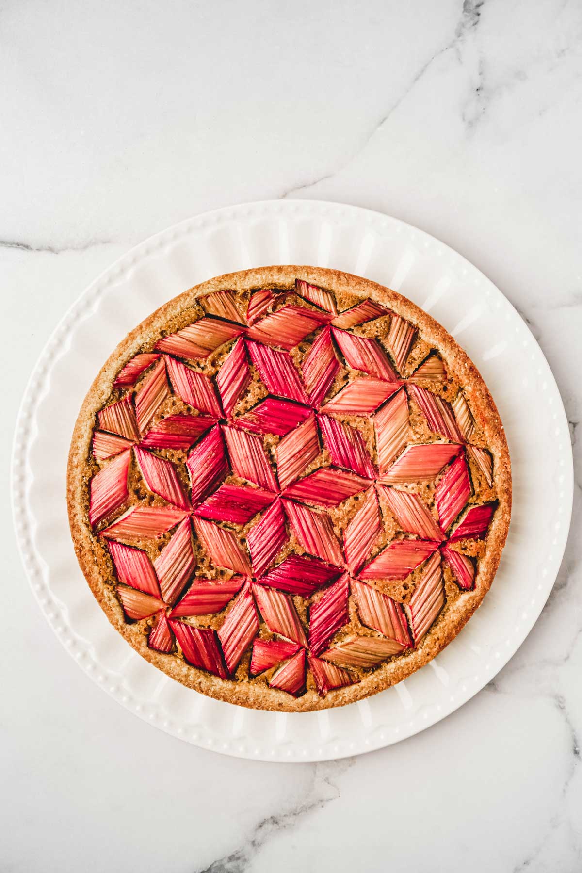 Grand assiette avec la tarte à la rhubarbe graphique aux amandes