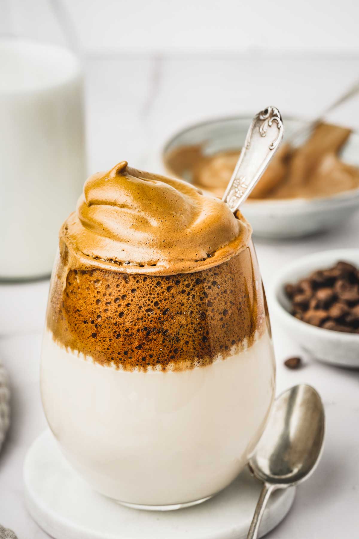 Verre avec du lait et une mousse de café fouetté