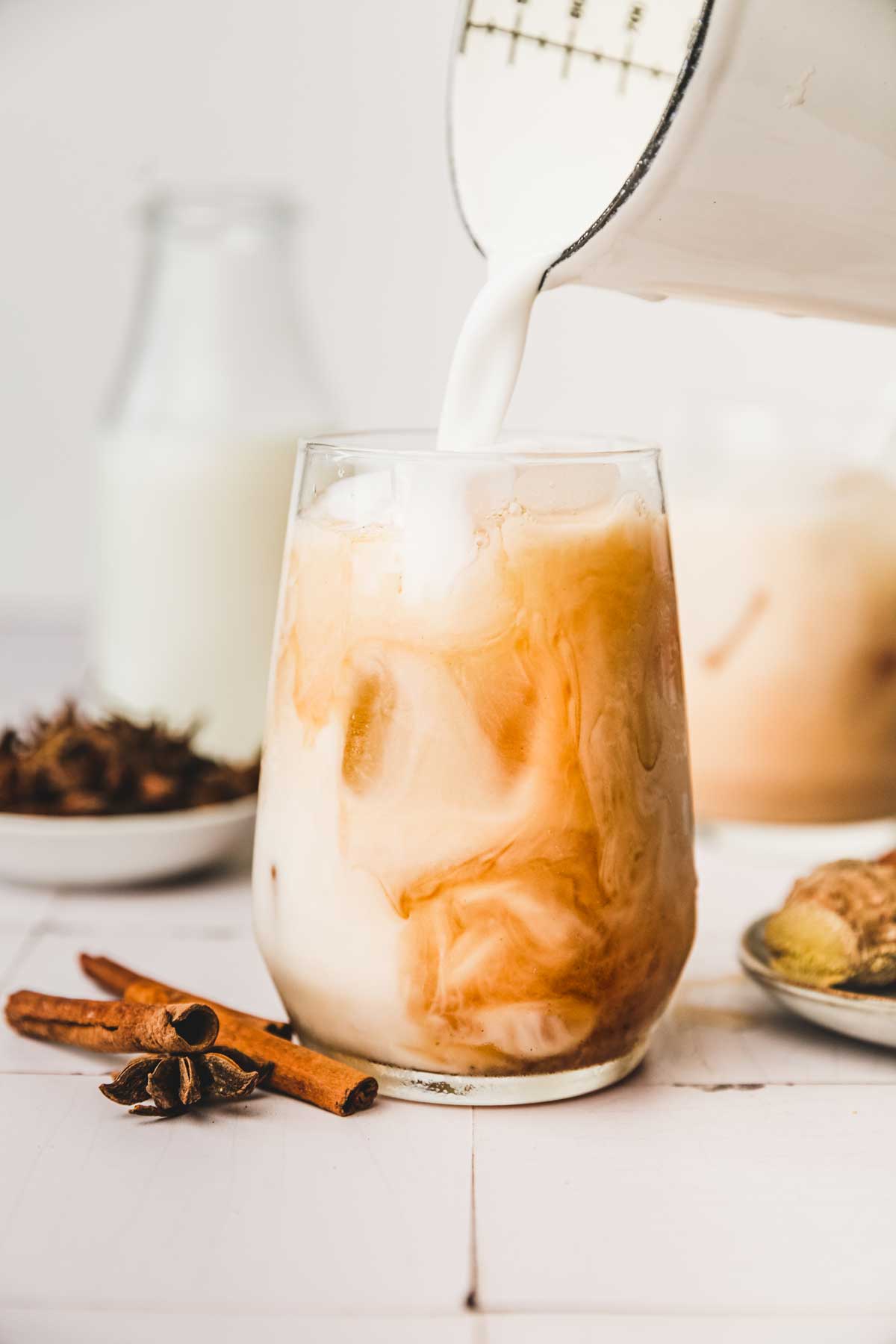 Lait versé dans un verre de thé noir