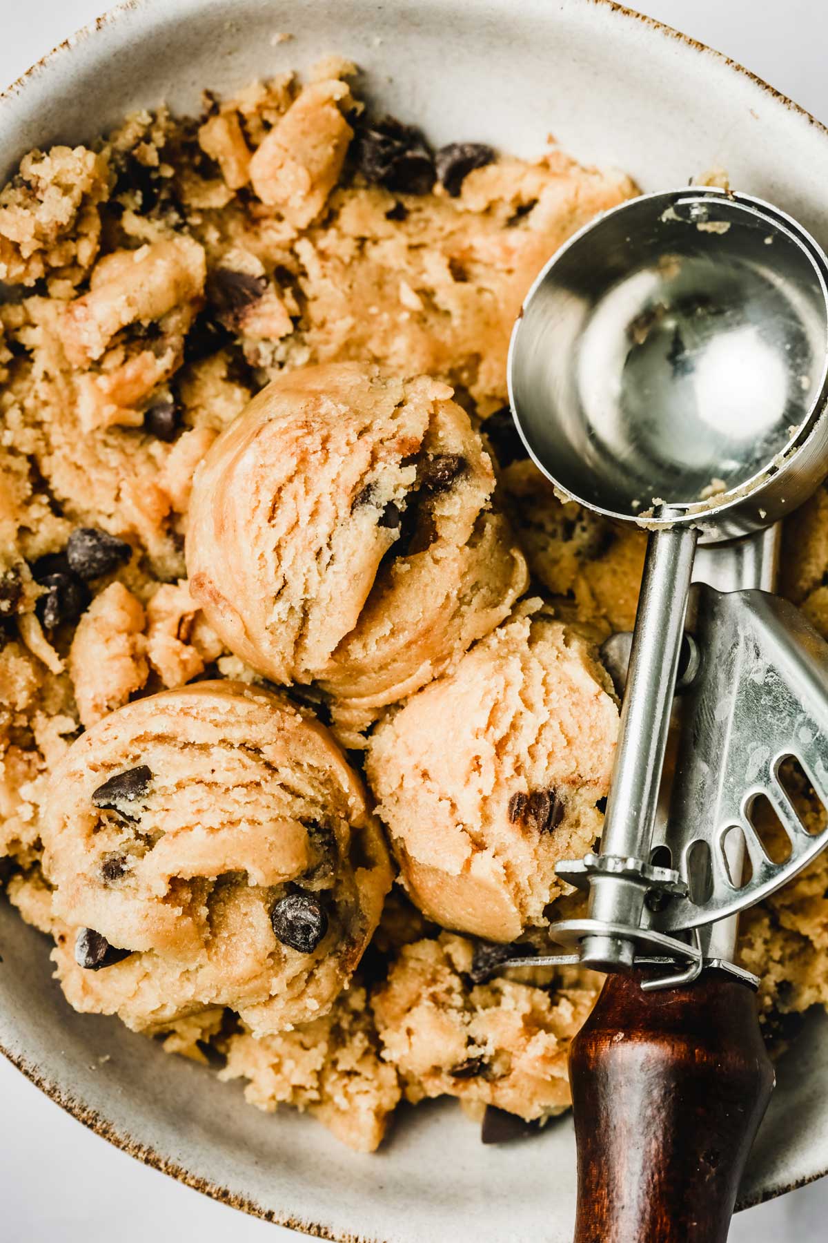 Bowl with ice cream scoop and cookie dough